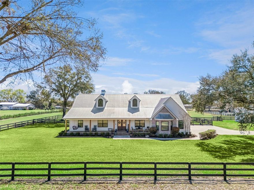 An extraordinary private estate spanning 10 pristine, agriculturally zoned acres — where timeless elegance meets boundless opportunity. With the potential to subdivide into two 5-acre parcels, this exceptional property offers a rare chance to create a legacy family compound or multi-generational retreat. Beyond the private electric gate, a majestic oak-lined drive creates a grand arrival. The picturesque front porch sets the tone for the refined interiors within. Inside, the elegant foyer immediately captures breathtaking views of the sparkling saltwater pool and serene rear pasture. The main living area showcases soaring ceilings and a dramatic floor-to-ceiling fireplace, blending architectural presence with warm sophistication. Luxury vinyl plank flooring flows seamlessly throughout the living areas and bedrooms, offering understated elegance and durability. A thoughtfully designed three-way split floor plan provides privacy and comfort, with a secluded front bedroom and two additional bedrooms sharing a full bath with convenient pool access. The chef’s kitchen features 42-inch solid wood cabinetry with soft-close doors and drawers, granite countertops, stainless steel appliances, a breakfast bar, dining nook, and an expansive walk-in pantry with integrated laundry and additional storage — ideal for both everyday living and elevated entertaining. The primary suite is a private sanctuary with direct pool access, a spa-inspired bath with dual vanities and oversized walk-in shower, and a custom walk-in closet. A dedicated office just off the garage offers flexible space for work or hobbies. Outdoor living is truly resort-inspired, with a screened-in saltwater pool and covered grilling area designed for year-round Florida entertaining. The expansive detached garage enhances the estate’s versatility, featuring a 20' x 20' private office with mini-split, two closets, and a half bath (convertible to full). A 42' x 24' covered area accommodates farm equipment or recreational vehicles. The impressive 62’ x 43’ enclosed garage with dual roll-up doors is ideal for collectors or hobbyists. An RV hookup with electric, water, and sewer off of the garage completes this country estate. New Metal Roof (2018), and nearly $100,000 in recent upgrades include, new windows and sliders, front and rear doors, generator hookup, updated appliances, salt cell, upgraded lighting and faucets, new outdoor fans and screens, kitchen filtration system, custom fireplace detailing, full interior paint, refreshed fencing, professional landscaping, sprinkler updates, and a new gate opener. A statement property offering privacy, prestige, and the serene freedom of Florida country living.