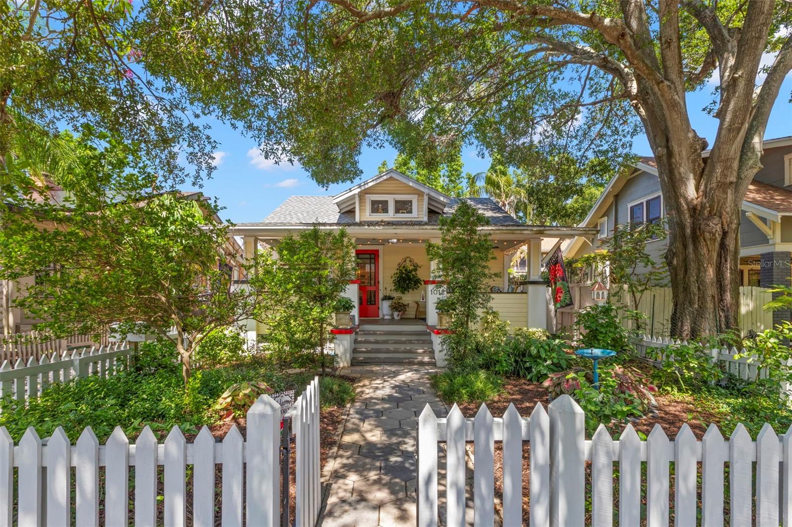 This renovated 1925 Craftsman bungalow is situated in the highly sought-after Old Northeast neighborhood. High and dry in a non-evacuation zone, it features custom black metal hurricane shutters for peace of mind that can stay up year-round. This quaint home boasts character and charm throughout, offering two bedrooms and two full baths with a downstairs living space of 966 sq ft, plus an additional 336 sq ft of finished upstairs space, ideal for a home office, music room, workout room, or flex space. The renovations thoughtfully preserved the 1920s era with shaker-style cabinets, wainscoting, hex tile bathroom flooring, trim moldings, and period lighting. Every square foot has been efficiently utilized, including built-ins throughout to maximize storage. Relax on the inviting porch that overlooks a xeriscape fenced in front yard with bird bath, perfect for gardening and bird watching. Custom built-in bookcases, a nod to 1920s design, define the living and dining areas. For those who love to cook, the kitchen provides a perfect workspace with gourmet features, including a dual-fuel Wolf natural gas range, soapstone countertops, a large apron sink with natural light from the casement window, custom wood shaker cabinets, subway tile, and schoolhouse lighting. The primary suite, located at the back of the home for privacy, features wainscoting, a clawfoot soaking tub, a marble vanity and walk-in closet with laundry. The second bedroom, overlooking the front porch, includes a custom shaker-style built-in closet. Heart pine wood floors and plantation shutters complete the interior, adding warmth and charm. Exit from the Dutch door to a fenced-in backyard that offers ample space for relaxation or entertaining, accented with a pergola and brick pavers.. Parking for up to four cars is available in the one-car garage and on the driveway—a rare convenience in this neighborhood. Schedule your private showing today to experience a blend of period charm with convenience in mind! The home is located within walking distance to restaurants and shops on 4th Street and is in close proximity to downtown and the waterfront.