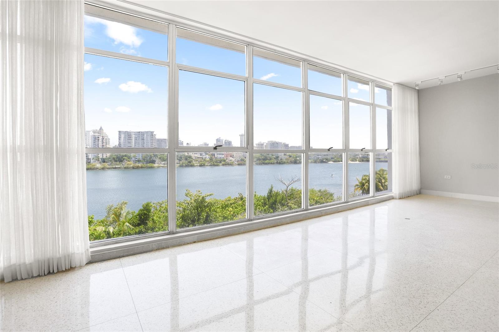 Wake up to breathtaking panoramic views of the Condado Lagoon. Thoughtfully designed with the finest attention to detail, this fully remodeled apartment showcases high-end finishes, natural stone accents, and premium appliances throughout. Enjoy direct access to the lagoon’s shoreline—perfect for morning walks or launching your paddleboard just steps from your door. The unit includes one deeded parking space, with an additional spot available on a first-come, first-served basis. A tasteful blend of elegance, comfort, and coastal charm.