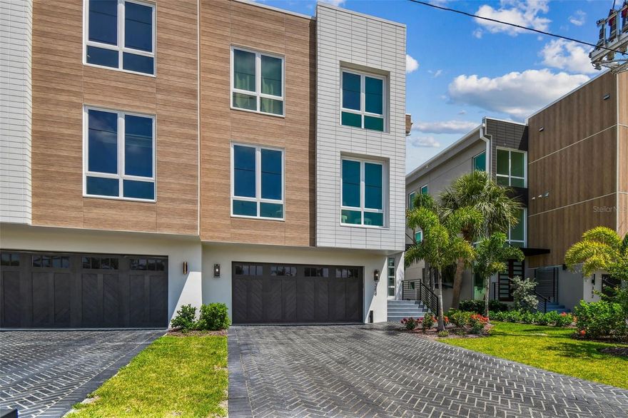 Completed Turnkey New Construction — Price includes all furniture or not, you decide.   Ready for a Fun-Loving Boater on Treasure Island, Madeira Beach, John’s Pass! Featured on HGTV’s Rock the Block, this stunning 3,638 SF custom-designed residence offers 5 bedrooms, 5 bathrooms, and an oversized 4-car garage with a work shelf area—plenty of space for all your water toys. Built to new elevation codes with solid concrete block construction, high-impact windows, and flood vents, this home provides peace of mind and effortless luxury living. Step into the expansive great room featuring a custom gas fireplace, coffered ceilings, and bi-fold doors that open to your outdoor oasis. The Chef’s kitchen is spectacular—showcasing premium built-in Jenn-Air refrigerator, 6-burner gas stove with double oven, built-in microwave in the island, double pantries, Kohler farm sink with designer faucet, custom cabinetry, quartz countertops, and a large center island ideal for gathering. This is truly a chef’s kitchen designed for both style and function. The dining area is enhanced by a built-in dry bar with solid wood cabinetry and designer lighting—perfect for entertaining. The primary suite is a true retreat, complete with a private balcony, elegant chandelier, and breathtaking water views. The spa-style bathroom offers a large walk-in shower, standalone soaking tub, private washroom with bidet, and an oversized walk-in closet with custom shelving, storage, and its own fireplace. Besides the obvious benefits of Treasure Island’s location, this elevated home boasts panoramic water views from every window—you’re never without a stunning backdrop. Enjoy resort-style outdoor living with a private heated pool and hot tub, sun shelf, and fully equipped summer kitchen. Spiral stairs connect the balcony to the backyard, making it easy to enjoy every inch of your waterfront paradise. This home offers a fenced yard, private boat slip, and direct access to the Gulf of Mexico via John’s Pass—just 5 minutes away. Don’t miss this rare opportunity to own a show-stopping waterfront property in a true boater’s paradise! All photos are actual photos—no renderings, no digital staging, and no staging furniture.