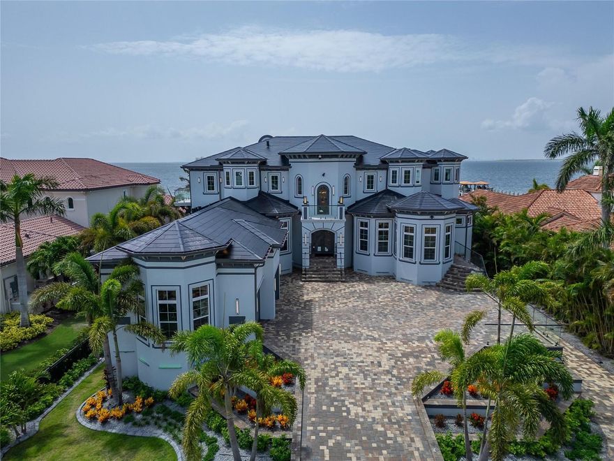 6526 Surfside Blvd | 7 Beds | 8 Baths | 12,700+ Sq Ft Living | 3,000+ Sq Ft Storage | Solar Powered by Tesla Solar Shingles | Private Dock | Direct Bay Access
Welcome to 6526 Surfside Blvd, Apollo Beach’s most iconic waterfront estate—designed for those who want room to live, entertain, work, and grow. With over 12,700 square feet of living space and nearly 3,000 additional square feet of climate-controlled storage, this custom-built, hurricane-rated home delivers unmatched flexibility and performance, inside and out.
Built on over 12 feet of elevation, with stem wall and solid block construction, this property offers both peace of mind and future-proof design. From the moment you arrive, the gated entry, oversized paver driveway, and lush tropical landscaping set the tone. The private dock offers direct Tampa Bay access for boating, paddleboarding, or fishing from your backyard. Retractable full corner-pocket sliders on both levels open the entire home to panoramic views of the Bay. Views of Tampa to the right and St Pete to the left while capturing stunning sunrises, breezes, and sunsets.
This home is as smart as it is spacious, with energy-efficient insulation, hurricane-rated noise-reduction windows and doors, a hardwired internal/external security system, seamless fire-rated hardware, and solar-powered design. The outdoor kitchen includes a retractable TV, gas grill, and custom lighting—perfect for weekend cookouts or hosting under the stars.
Inside, there are 7 full-size bedrooms and 8 bathrooms, plus a mix of flexible-use spaces: media room, home office, in-law suites, lounges, or additional guest quarters—whatever your needs, this home adapts. The main kitchen is built to host, with a massive island, gas cooktop, double ovens, butler’s pantry, freezer, wine fridge, and high-end appliances throughout. A formal dining space with a built-in wine wall creates a showpiece moment for dinners and entertaining.
The primary suite is located on the main floor with bay views, private pool access, a serene sitting area, and a spa-inspired bath featuring a jetted tub, walk-in rain shower, dual vanities with built in smart screen, and a custom closet with center island and dressing area. Two secondary bedrooms also provide private ensuite bathrooms. Additional bedrooms upstairs are spacious, modern, and share access to expansive wraparound balconies with glass railing and glass floor panels for a dramatic look down to the outdoor living space.
Other standout features include:
Fully furnished with high end- custom Bentley furniture
Tesla charging stations
Garage parking for up to 10 vehicles, with workshop and gear storage areas
Custom home theater with recliners for 10, full surround sound, and projector
Wet bar and lounge on upper level
Washer and dryer on both floors
Multiple balconies with unobstructed views of Downtown Tampa and St. Pete
All of this sits within a tight-knit, waterfront community, minutes from local restaurants, beaches, schools, and commuter routes. 
This isn’t just another large home on the water—6526 Surfside Blvd is a one-of-a-kind Florida lifestyle property built for multi-generational living, serious entertaining, and long-term peace of mind. If you’ve been searching for something truly extraordinary in the Tampa Area—this is it.