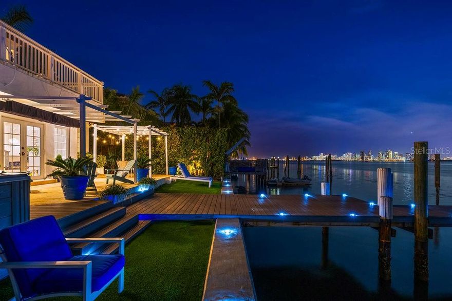 Discover timeless elegance intertwined with Florida's enchanting charm in this breathtaking Key West-style waterfront home, nestled within the secure gates of North Bay Island in North Bay Village. This remarkable residence invites you to bask in panoramic vistas of the expansive bay and the dazzling downtown Miami skyline, complemented by the awe-inspiring beauty of sunsets gliding across the waters. Constructed in 1940, this two-story jewel maintains its historical allure while offering modern comforts. The completely remodeled home boasts exquisite hardwood flooring throughout. It comprises four luxurious bedrooms, each with an en-suite bathroom.