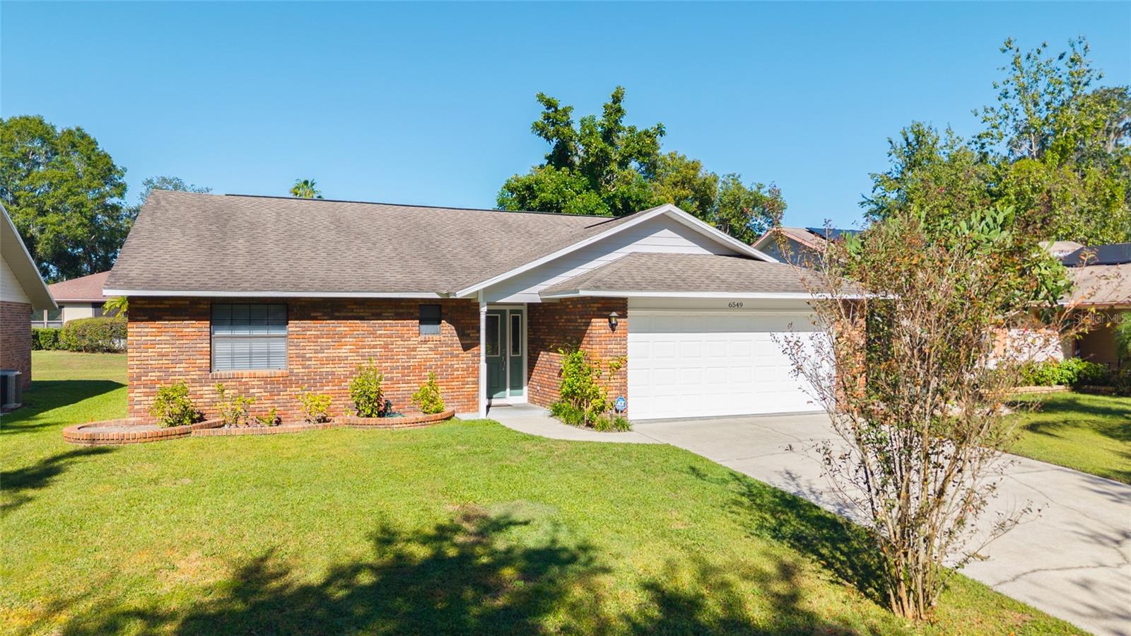 Welcome to Silver Oaks Golf Community! This beautifully maintained 2-bedroom, 2-bath home with an additional office space offers comfort, style, and countless updates! Wind through this desirable Zephyrhills neighborhood and arrive at this charming home with updates galore! Step inside the foyer and you’ll immediately notice the lovely laminate flooring that continues throughout, with ceramic tile in both baths. The living room serves as the central hub, open to the dining area and kitchen—perfect for entertaining! A soaring 12-ft vaulted ceiling enhances the bright, airy feel. French doors lead to the open patio and backyard, ideal for relaxing or weekend gatherings. The updated kitchen features granite countertops, stylish cabinetry with open shelving, stainless-steel appliances, and a tile backsplash. A bonus space off the living area offers built-in bookshelves, crown molding, and a cozy window seat—perfect for a home office, reading nook, or craft area. The split bedroom plan provides privacy, with the primary suite offering a walk-in closet with custom shelving and a remodeled bath complete with dual sinks, tiled shower, and rain shower head. The second bedroom and hall bath are equally inviting and beautifully updated. With LOW HOA fees and a prime location near shopping, dining, golf, and medical facilities, this home is move-in ready and an absolute must-see!