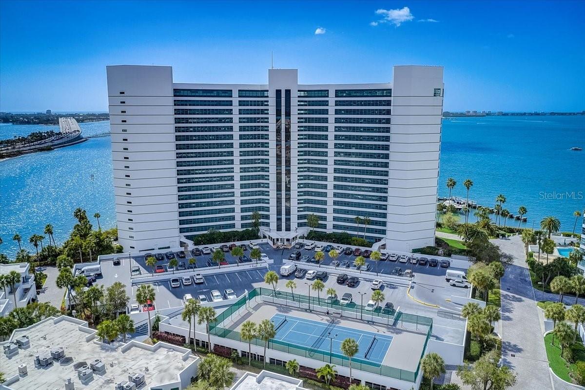 Wake up to panoramic views of Sarasota Bay in this fully renovated 2/2 condo with wrap around windows. Welcome to Condo on the Bay, an exclusive direct bayfront playground where everyday feels like a vacation. Residents enjoy the many amenities including resort style heated pools, boat and kayak docks, fishing piers, tennis & pickleball courts, electric car charging station.. It is situated on a 9 acre gated peninsula with 24 hour security and is located next door to the world class Bay Park and Van Wezel theatre. It's the perfect homebase for exploring the Park ,attending events downtown or going to restaurants This 8th floor condo was fully renovated in 2017, the AC was new in 2024 and a tankless water heater installed in 2022. The kitchen boasts white shaker Kraftmaid cabinetry, quartz countertops, wine cooler, SS GE applicances. The living area is surrounded by windows and the floor to ceiling sliders open to a lanai just off the dining area. Hunter Douglas dual sheer shades are installed throughout the condo. The primary ensuite includes a walk in custom closet and a shower, dual sinks. The spacious guest room has a murphy bed and also serves as an office. The guest bath is a combo tub/shower with a rain shower head. Hurricane sliders were installed in 2017. The main living area has been opened up to create more floor space that was previously wasted adding to the sq footage. The condo could be sold turnkey as an option. If you looking for a place to dock your boat or kayak or go fishing you could not ask for more convenience than walking out your front door. Lido Beach is only 2 miles away, the airport 4 miles and the world famous Siesta Key Beach 5 miles. Looking to make friends? Condo on the Bay is a very friendly community. There are organized social events, happy hours, dining out, majong, water aerobics, walking groups and get togethers for no reason. Your Hoa fee includes all but your electric bill.
