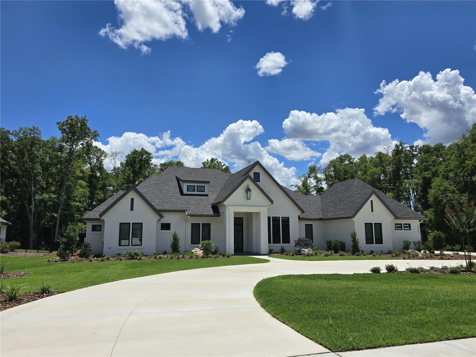 Introducing this breath taking home crafted on a beautiful lot in Oakmont. Meticulously designed and constructed by Barry Bullard Homes, this remarkable residence spans an expansive 4694 square feet, offering a seamless open concept floor plan that bathes every corner in an abundance of natural light, complemented by captivating glass elements throughout. With a thoughtfully planned layout, this home presents 4 bedrooms with 4 ensuite bathrooms and two additional half baths, a study with built-in cabinets for quiet contemplation, and a versatile flex room that effortlessly connects to a generously sized lanai. The great room stands out with its awe-inspiring raised sectioned tray ceiling with decorative beams, moldings and up lighting. A gas fireplace with a custom precast stone surround creates a cozy ambiance, while built-in cabinets provide both functionality and style. The heart of the home is every culinary enthusiast's dream kitchen. It boasts a sprawling island and top-of-the-line Thermador Pro appliance package including 48” Dual Fuel range, custom made metal vent hood, 48” Built in refrigerator, dishwasher, microwave drawer, one large main sink, a prep sink and a capacious walk-in pantry. The bar area includes a wet icemaker, 2 wine refrigerators, floating island with bar top, and a bar sink. The great & dining rooms extend seamlessly outdoors through a stack of French doors, leading to a spacious outdoor entertaining area. This enchanting patio is fully paved and offers a resplendent pool with a sun shelf, and a mesmerizing water feature. A large covered lanai featuring motorized drop down screens, outdoor fireplace with stone surround, a summer kitchen featuring a built-in grill and sink further enhances the outdoor oasis. The master suite serves as a true sanctuary, encompassing two walk-in closets, separate vanities, a sizable walk-in shower, and a freestanding soaking tub for indulgent relaxation. Energy efficiency takes center stage in this home, thanks to its cutting-edge features including spray foam insulation, tankless hot water heaters, two HVAC systems split into 4 zones for high-efficiency heating and cooling, LED recessed cans, and vinyl insulated low E windows. Elevating the interior to new heights, this residence showcases upgraded finishes throughout. Wood Plank flooring graces every room except the bathrooms, clean modern interior trim adds a touch of elegance, cove crown molding adorns the common areas and master suite. Enhanced plumbing and lighting fixtures further amplify the home's luxurious appeal. The laundry center offers convenience with its practical folding top, and a 3-car garage adds ample space for vehicles and storage. Externally, the home is adorned with stucco finish. The property is situated on a meticulously landscaped 1-acre lot surrounded by open common space on two sides, providing a picturesque backdrop for everyday living. In its entirety, this newly constructed masterpiece within Oakmont epitomizes the pinnacle of luxury living, showcasing remarkable design features and modern conveniences that cater to your every desire.