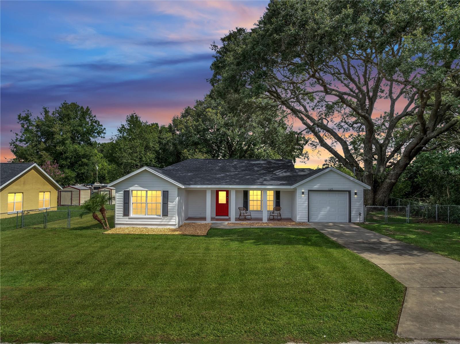 Welcome to this beautifully renovated 3-bed, 2-bath home tucked under mature oak trees in the heart of Ocala. From the charming front porch with a bold red door to a brand-new roof and fresh exterior paint, this property is move-in ready and full of curb appeal. Inside, you’ll find a bright open layout with vaulted ceilings, tile and vinyl flooring throughout, and a spacious living room that flows seamlessly into the dining area and updated kitchen. The modern kitchen features new granite countertops, new cabinetry, stainless steel appliances, and a large middle island, while the indoor laundry area includes a new washer and dryer for everyday convenience.
Both bathrooms have been stylishly updated, and all bedrooms are comfortable and filled with light. Outside, the large fenced backyard offers a lush quarter acre for entertaining, gardening, or relaxing in the shade. With no HOA, a one-car garage, and easy access to shopping, dining, schools, and major roadways, this home offers modern upgrades in a peaceful, established neighborhood. Schedule your private showing today and see why 645 NW 65th St is the perfect Ocala find!