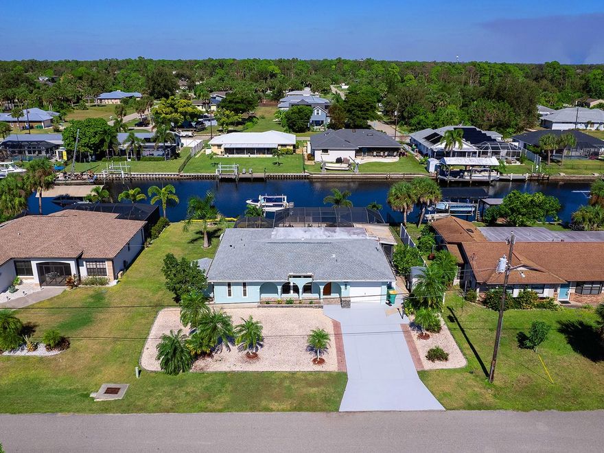 Discover the best of Florida waterfront living in this beautiful canal-front pool home, ideally just minutes from open waters of Charlotte Harbor. A low-maintenance, xeriscape yard, freshly painted exterior, custom front entry door, and generator transfer switch create a strong first impression before you even go inside. Once indoors, sweeping views of the pool and canal immediately take center stage. This thoughtfully designed two-bedroom, two-bath home offers a comfortable layout that includes a spacious den and an expansive air-conditioned bonus room, ideal for entertaining, hobbies or simply enjoying serene water views. The kitchen is functional and inviting, featuring warm wood cabinetry and stainless steel appliances. A new roof installed in 2023 adds peace of mind for years to come. Outdoor living is a highlight, with an oversized screened lanai ideal for gatherings or quiet afternoons spent watching boats pass by. Boating enthusiasts will appreciate the concrete seawall, large wood dock and 10,000-pound boat lift, making water access effortless. Additional features include an extra-wide driveway and a large storage shed conveniently along the side of the home. Set in a friendly community and close to shopping and dining, this home offers an exceptional opportunity to enjoy relaxed waterfront living without sacrificing convenience.