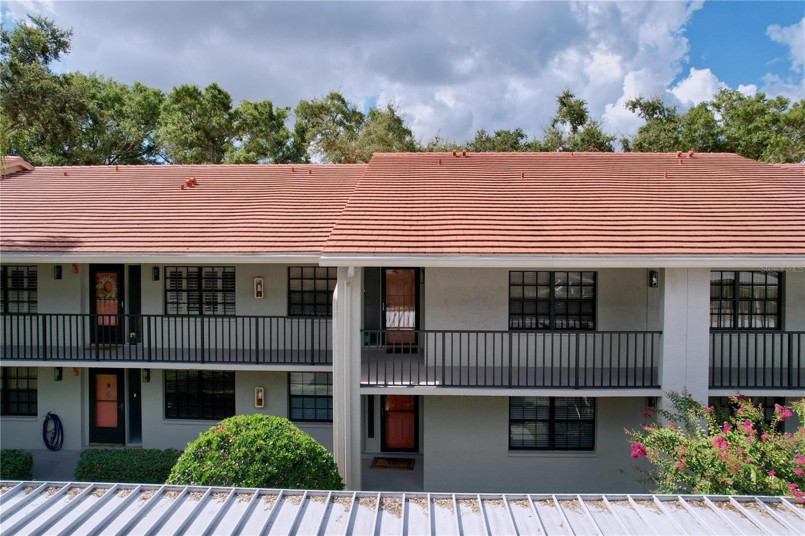 MUST SEE! Experience serene lakeside living in this charming 2BR/2BA second-floor condo, located in the beautifully maintained 55+ community of Villas of Lake Arbor. Enjoy breathtaking water views from the heated community pool or take a peaceful stroll along the fishing pier overlooking the sparkling lake. This light-filled condo features vaulted ceilings, a spacious living/dining area with wet bar, and an eat-in kitchen with stainless steel appliances, newer wood-look LVP flooring, and a convenient breakfast bar. The private primary suite offers a walk-in closet, en-suite bath with walk-in shower, and direct access to the screened, covered lanai—perfect for enjoying the gentle lake breeze. Additional highlights include a full-size laundry room, assigned covered carport, outdoor storage closet, and ample guest parking. HOA covers water, trash, cable, internet, roof, exterior maintenance, and building insurance. Pet-friendly. New roof in 2023. NO FLOOD ZONE or EVACUATION ZONE. Minutes to Clearwater & Dunedin Beaches, Countryside Mall, top recreation, dining, and airport. Carefree Florida living at its finest—schedule your private showing today!