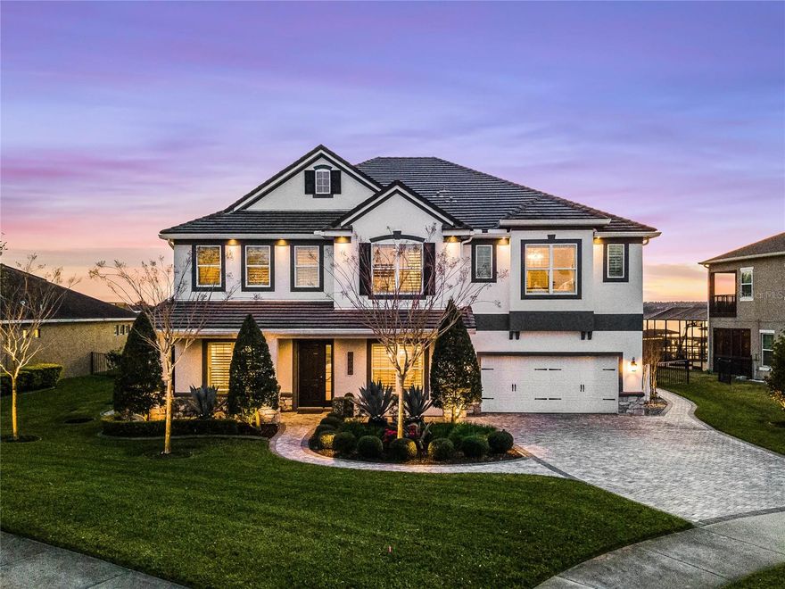 BETTER ACT FAST ON THIS ONE-OF-A-KIND, LAKEVIEW HOME IN A POPULAR GATED COMMUNITY! Enjoy nightly sunsets with an incomparable view of the pristine Johns Lake with this luxury two-story home. With a wide range of upgrades and enhancements throughout almost 5,000 square feet of living space, this gorgeous home provides space for everyone in the family including a conversation room with custom woodwork, large dining room and and a spacious family room, all with attractive, dark wood framing and ceiling beams. The open floor plan looks out to the custom, infinity pool and spa with spectacular fire bowls, custom lighting and a phenomenal lake view. Your backyard oasis is perfect for relaxing or entertaining friends with its shellock pavered (heat resistant) lanai, stonework pillars, outdoor fireplace with seating area and high-end outdoor kitchen featuring custom cabinetry, an inviting island bar, flat top and gas grill, dual tap kegerator, refrigerator and ice machine. The backyard retreat also boasts professionally designed landscaping, an outdoor lighting package and your own boat dock equipped with electric, water and two floating jet ski spaces. The gourmet kitchen includes stainless steel appliances, granite countertops, 42-inch cabinets, a custom range hood, subway tile backsplash, walk-in pantry and an oversized waterfall quartz island and plenty of storage. The first floor also features a guest suite complete with full bath. Upstairs you’ll find a large bonus room with wet bar, media room with projector and screen, home office and three additional bedrooms with walk-in closets. The owners suite features a tray ceiling, two walk-in closets and primary bathroom with separate vanities, granite countertops, garden tub and separate shower plus a balcony that stretches along the entire back of the home with an incredible view of the pool and lake.  Additional upgrades include luxury vinyl flooring throughout first floor and second floor common areas, pavered driveway and sidewalk, crown moulding throughout, wood paneled ceilings on front and back porch, water softener, three-car tandem garage and recent exterior paint. Hickory Hammock is a gated neighborhood the best of Florida living, a resort-style pool with a multi-function clubhouse, volleyball courts, tennis courts, workout facility, community dock, playground, dog park and a walking trail. Low HOA dues and A schools make this home better than all the rest. Conveniently located to downtown Winter Garden, Fowler's Grove shopping and major highways. This home has it all, better act fast on this truly special home!