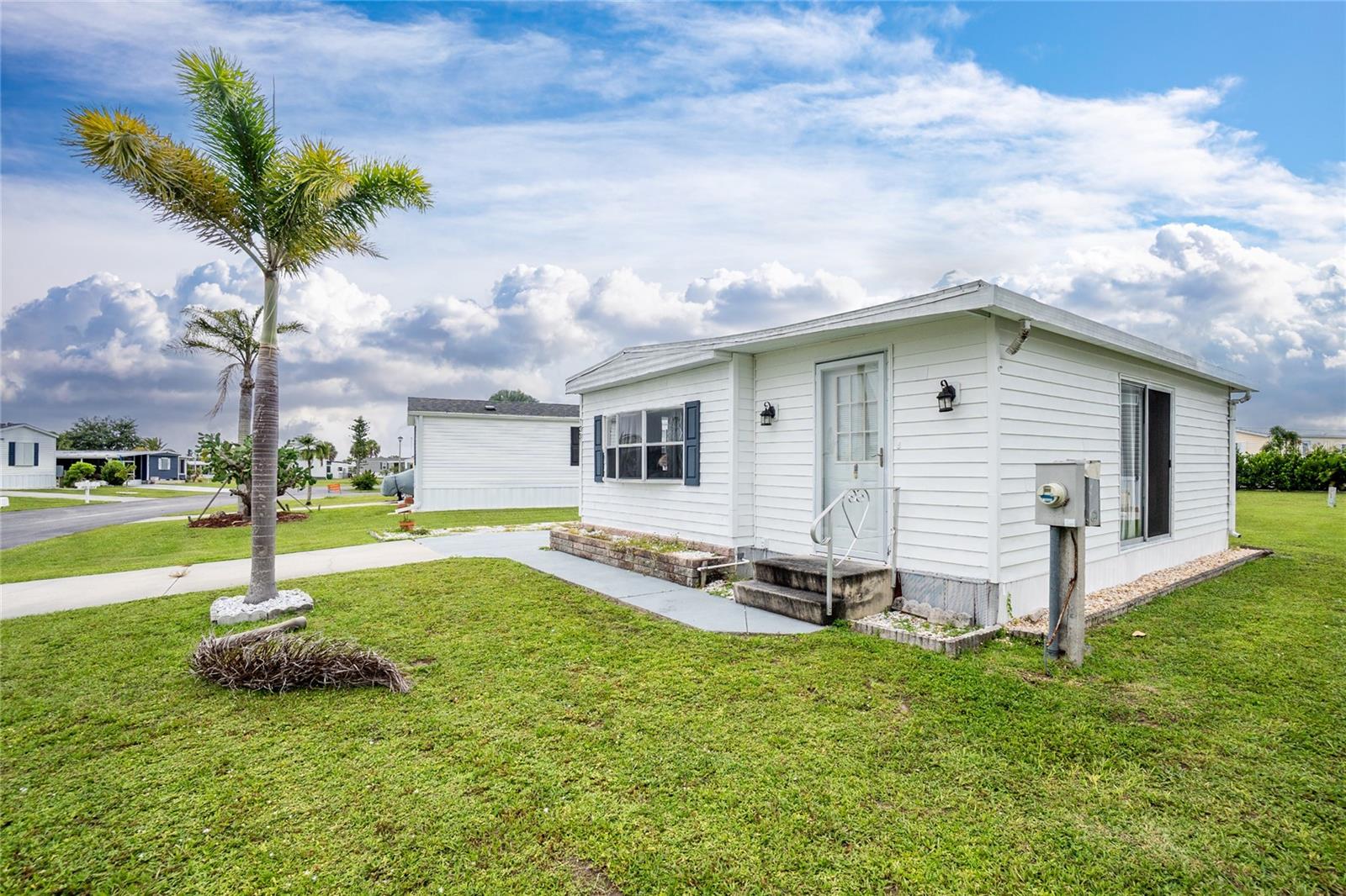 Welcome to the Village of Holiday Lake, an active WATERFRONT COMMUNITY where neighbors become friends, and every day feels like a vacation! This is a 2 bedroom/2 bath home with a 10 X 24 BONUS ROOM. This home is being sold TURNKEY. The kitchen offers plenty of cabinetry and counter space for meal prep and cooking. The primary bedroom features a built in closet. The second bedroom is spacious and sure to please visiting friends and family. The oversized bonus room can be used as a third bedroom or a grand room for entertaining. ROOF 2022, AIR CONDITIONER IS 2024. Outdoors you’ll find 2 sheds adding the ease of having extra storage space and a laundry area.
OWN YOUR OWN LAND, GOLF CART COMMUNITY.
ALL AGES WELCOME.
The Village of Holiday Lake offers an array of resort-style amenities where you will enjoy a low monthly maintenance fee of only $140 per month which includes the amenities and mowing of the grounds. Golf cart-friendly community with optional storage for your R/V or boat. The expansive clubhouse with a full kitchen serves as the focal point for community gatherings, dinners and dances. The Village boasts 25+ boat slips, beautiful pool area with 2 POOLS and BBQ area. In addition you will find a craft room, FITNESS CENTER and laundry facility along with areas for woodworking, tennis, PICKLEBALL, shuffleboard and more. The outdoor enthusiast in you will love the closeness of boating and fishing from the COMMUNITY DOCKS and BOAT RAMP. You will also find several Gulf Shore BEACHES CLOSE BY. The foodie in you will love the local delights like Gerry’s Tiki Hut, TT’s Tiki on the Water and the Sandbar Tiki & Grill all of which can be accessed by boat or by car. The Village is perfect for year-round living or a winter get away spot.