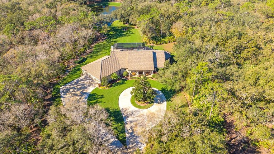This warm and inviting custom designed home, located right outside of Lakewood Ranch, offers luxurious country living at its finest as well as unparalleled privacy.  The estate is nestled on a heavily wooded 17+ acres in the heart of Panther Ridge, with breathtakingly expansive vistas at every turn.  Great care was used to site the home and preserve the stunning 100-year-old oak trees that surround the home, whilst creating amazing views of nature from every window.  To enter the property, cross your private bridge over a quiet creek, then enjoy an impressive drive down the long winding concrete driveway that leads to the gates of the property.  Here, you will feast your eyes on a one of a kind, once in a lifetime property.  With 3,262' square feet of living space, a 1200’ 4-car garage, and a vast outdoor sanctuary, this home provides plenty of breathing room and also provides the ability to add a guest home plus a workshop or barn (HORSES ALLOWED)!  The 4 bedroom 3 ½ bath home features volume ceilings, an amazing array of windows for natural sunlight, tray ceilings, a combination of solid hardwood and porcelain flooring, recessed lighting, crown molding and granite/quartz countertops throughout, a wood burning stone fireplace in the family room, outdoor kitchen, and concrete curb around the mature lush landscaping.  This home’s outdoors delivers a sprawling pavered lanai with abundant under cover space, summer kitchen, and an inviting 33' x 16' pool and spa with views of moss-covered oak trees and a private lake. Seamlessly connecting the resort-styled oasis are glass sliders into the oversized living and great room, and a gourmand’s kitchen as well as a HUGE laundry room. Relax and unwind in the elegant owner’s retreat positioned on its own private wing behind double French doors, offering direct lanai access, walk-in customized closets, and a luxurious spa-like bath with dual vanities, walk-in shower, and soaking tub.  On the opposite side of the home, is a second ensuite, and a massive laundry room complete with a folding counter, sink and a phenomenal number of cabinets. The grand kitchen is a chef's dream, boasting granite countertops, stainless steel appliances, double ovens, separate microwave, and walk-in pantry, making this kitchen the perfect hub for entertaining. The kitchen overlooks the breakfast nook and family room, all featuring volume ceilings, recessed lighting, and tall sliding doors that offer serene views of the pool and property. The expansive 17+ acre parcel offers endless possibilities, whether you dream of a flourishing garden, a private oasis, or a place to explore and enjoy nature. 3+ acres are fenced and the property provides access to the 15 miles of hiking and equestrian trails. This exceptional property provides the canvas upon which you can paint your ideal lifestyle. Panther Ridge offers charming country living with estate-property distinction. There are neighborhood parks that include soccer and baseball fields, a tennis court, plus basketball courts and jungle gym for the kids.  Located approximately 25 minutes from downtown and 15 minutes to the University Parkway shopping corridor, you can enjoy the peacefulness of the country and still be within minutes of modern conveniences.  This property is High and Dry (Zone X) NO flood insurance required.   Panther Ridge Video https://pix360.com/vtour/9765/ CONTIGUOUS PROPERTY AVAILABLE 11+ ACRES A4600738  23312 RED ROBIN PL, BRADENTON, FL 34202