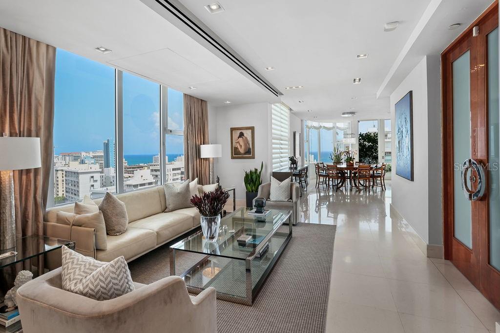 Experience urban luxury in this stunning sub-penthouse at The Residence at the Park, an exclusive boutique condominium perfectly situated across from Stella Maris Park, on the corner of Luchetti and Cervantes Streets—one of Condado's most sought-after addresses.
This northeast-facing unit spans 2,936 square feet of impeccably designed living space, including an elegant living room, an inviting dining room, a versatile home office/family room, four bedrooms, three full bathrooms, one powder bath, and four covered parking spaces. The fully equipped gourmet kitchen, spacious primary bedroom with a walk-in closet, and additional storage and laundry room enhance convenience. The charming balcony, adorned with greenery and a fountain, offers the perfect spot to enjoy panoramic views of the city, park, and ocean.
Residents enjoy top-tier amenities, including a 24-hour doorman, a full backup generator, a water cistern, a fitness center, and a residents' lounge. The generous proportions, light-filled open spaces, exquisite finishes, and captivating vistas make this property truly unique.
Don't miss the opportunity to live in Condado, near St. John’s and Robinson schools, parks, restaurants, the beach, shopping, and more. Make this exceptional property your new home and enjoy all that this vibrant neighborhood offers.