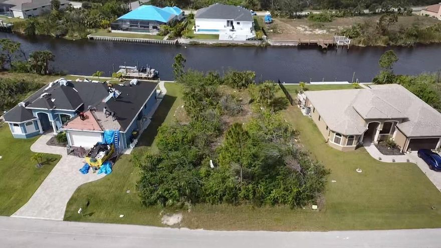 Pre-Construction. To be built. Waterfront Home with 3-Car Garage & Western Sunset Views! Experience the ultimate in coastal Florida living with this 3 bedroom, 3 bathroom home featuring a spacious 3-car garage and western exposure for breathtaking sunset views over the water. This home is currently under construction, and buyers may still make selections as long as materials have not been ordered. Please note: Photos shown are of similar completed homes, and certain finishes cannot be guaranteed. Designed for elegance and functionality, the home includes PGT impact-rated windows and doors, spray foam insulation in the ceiling, plank tile flooring throughout, tray ceilings, and crown molding. The open-concept layout maximizes natural light and provides ample space for both entertaining and everyday living. The gourmet kitchen features soft-close cabinetry, Level 3 granite countertops, stainless steel appliances, and a large island perfect for cooking and gathering. The primary suite serves as a private retreat with serene water views, a walk-in closet, and an en-suite bath with dual vanities and a spa-inspired rain shower. Two additional guest bedrooms each have their own bathrooms, providing comfort and privacy for family or guests. Step outside to your west-facing pool and screened lanai, ideal for enjoying sunsets over the water. The exterior is finished with upgraded Floratam grass and an irrigation system, and a seawall is already in place for waterfront enjoyment. This home combines modern upgrades, thoughtful design, and the perfect setting to embrace the coastal lifestyle.