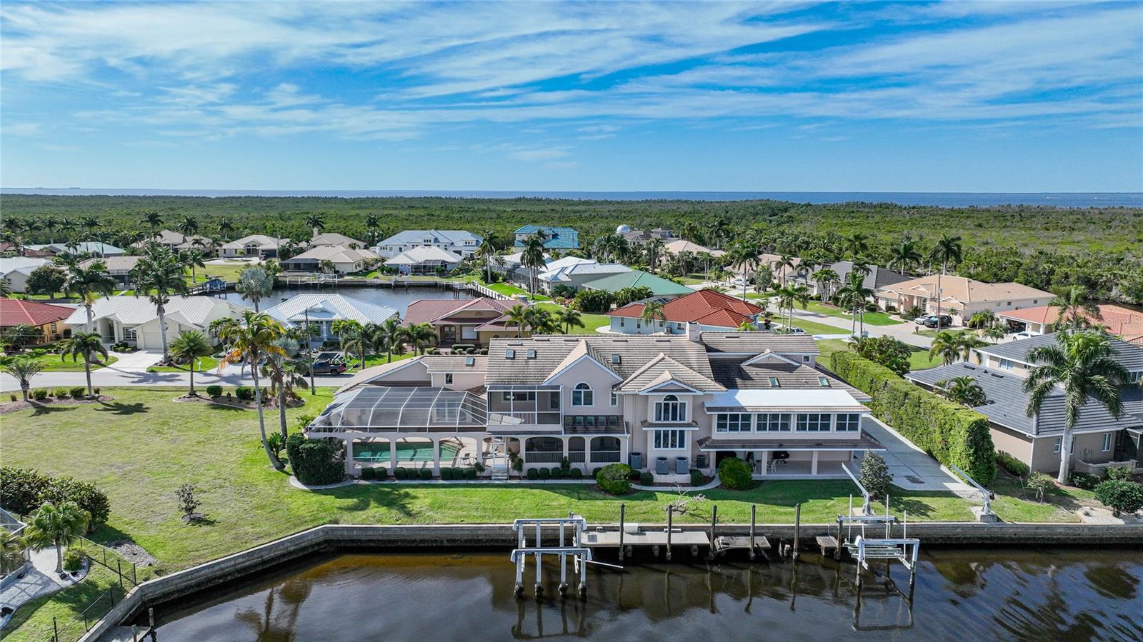 SELLER SAYS BRING ALL OFFERS!!!! Located in the highly sought after community of Punta Gorda Isles, this one-of-a-kind, waterfront, furnished home features 208 feet of seawall with sailboat access to Charlotte Harbor and out to the Gulf of Mexico. The custom built home boasts an incredible 9953 square feet under air, including 5 bedrooms, 4 full baths, 2 half baths, 2 offices, game room, Florida room, fitness room, and a large loft. As you enter through your grand foyer, you will be greeted by amazing craftsmanship throughout! The well appointed kitchen has a large center island, stainless steel appliances, a 5 burner glass cooktop, solid wood cabinets, pull out drawers, and a dining space. You will enjoy the luxury of two separate living areas, one with a wood burning fireplace. There are many skylights throughout the home to let in the natural light. The primary suite features a large bedroom with an amazing custom closet, a private balcony overlooking the water, and an en-suite bath. The bathroom has dual vanities, a dual entry shower, a separate soaking tub, and another walk in closet. The guest bedrooms all have oversized built in closets and are on the opposite side of the home to allow privacy for your guests. The interior laundry room has newer appliances and plenty of added cabinetry for storage. Enjoy spending time living the Florida lifestyle on your oversized screened in lanai, soaking in your private pool or in your hot tub overlooking the canal. You are just steps away from your concrete dock & boat lifts with quick boating access to open water. The 6 car garage is perfect for a car collector PLUS there is a tool room and a workshop with a half bath. Other features include: a gorgeous spiral staircase, Moen fixtures, thermostat controlled pool, WiFi enabled sprinkler system, crown molding, solar lighting, and so much more. Conveniently located to shopping, dining, Fishermen's Village, downtown Punta Gorda, golfing, medical, parks, and walking trails. This amazing estate with almost an acre of land has endless possibilities. Call today for your private showing!