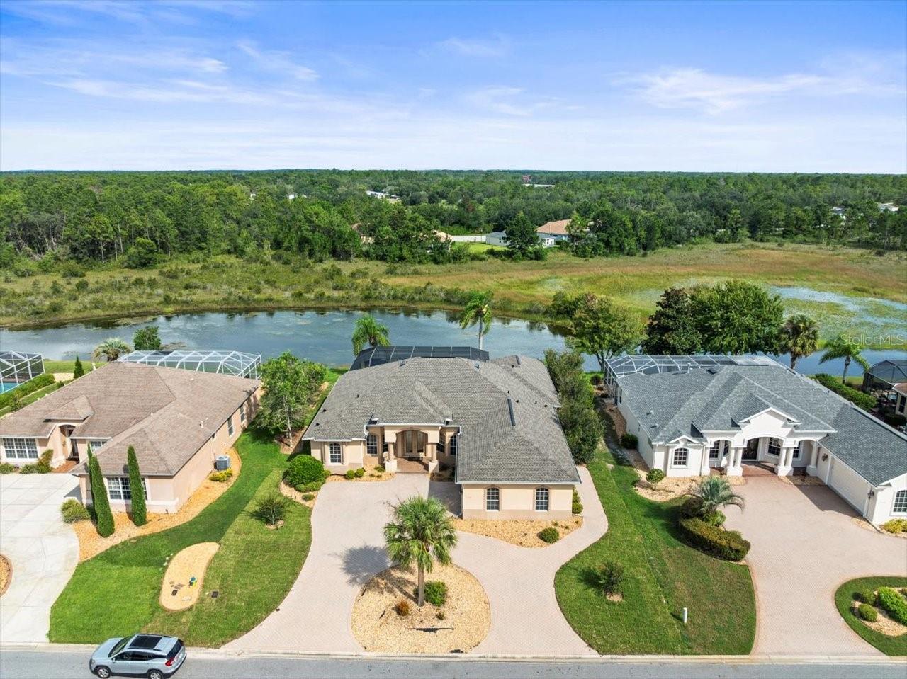 Located in Glen Lakes. Beautifully updated 2003 Addison Custom pool home on .31 acre and backing to a conservation area with pond for a very peaceful setting. NEW ROOF IN AUGUST OF 2025! 3 bedrooms+den/3 baths/2 car+golf cart garage. Large circular driveway with pavers, outdoor landscape lighting, stone bedding. The pool (16 ft. x 28 ft.) plus in-ground spa are heated by electric and gas. Oversized paver pool deck can accommodate all of your entertaining needs. The paver lanai is 13 ft. x 24 ft. Twin AC units. Enter this home through double leaded glass front doors. THIS HOME HAS A SELF-CONTAINED IN-LAW SUITE with a bedroom/full bath (shower only)/full kitchen/family room with murphy bed and both a door and sliding doors to the pool area. This area also has its own thermostat. Off of the in-law suite is the 2nd bath and 3rd bedroom. High flat ceilings throughout, engineered hardwood in bedrooms/formal dining room/den and 18 inch tile elsewhere. Great room with 3 sliders to the pool area/wet bar with wine cooler/electric fireplace/crown molding. The formal dining room has double glass doors and the den off of the great room also has double glass doors and lots of built-in cabinetry. The primary suite has double door entry, a sitting area, a door to the pool area, double crown molding with lighting, twin walk-in closets, a walk-in shower, jetted soaking tub, double sinks with granite counters and separate vanity area with granite. The breakfast area is large (10 ft. x 12 ft.) and windows overlooking the lanai/patio/pool. The kitchen has beautiful granite counters, white cabinets, closet pantry, LG stainless steel appliances. The laundry room is 6 ft. x 15 ft. and has a sink, included washer and dryer and loads of storage cabinets. This is a light and airy house and move-in ready. 3141 living sq. ft., 4275 total sq. ft. HOA FEES INCLUDE CABLE AND HIGH SPEED INTERNET AND PRIVATE MAINTAINED STREETS, 24 HOUR SECURITY WITH MANNED GATE. Glen Lakes is a wonderful gated and manned golf course community and surrounded by the 85,000 acre Chassahowitzka National Wildlife Refuge. The required social membership gives access to the clubhouse, restaurant, bar, Jr. Olympic size heated pool/spa, fitness center, clay tennis courts, pickleball courts and a vast array of social clubs. Golf memberships also available.