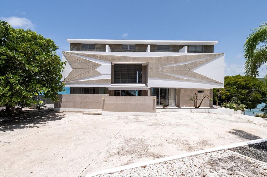 Villa Mariposa is a luxurious retreat set in the enchanting coastal town of Guánica, Puerto Rico. Designed by esteemed architects Alberto and José Dueño of the local firm TagD2, this exceptional property offers a perfect blend of architecture, tranquility, and breathtaking waterfront views.

The villa features five elegantly appointed bedrooms and four and a half bathrooms, creating an indulgent haven for the discerning homeowner. Every detail in this Mediterranean-inspired masterpiece reflects meticulous craftsmanship, seamlessly combining sophistication with comfort. The grand foyer welcomes you with natural light cascading through expansive windows, illuminating the open-concept living spaces.

The gourmet DOCA kitchen, outfitted with custom cabinetry and a spacious island, is designed for both culinary excellence and casual dining. The open floor plan, which extends to the outdoor living areas, makes this home ideal for hosting and entertaining. The Italian dining room table, crafted from wood salvaged from Venice gondolas and designed by German architect Piet Hein Eek, adds a unique touch to the dining experience.

The master suite is a serene sanctuary featuring panoramic views of the Caribbean Sea. The spa-like master bathroom is a retreat in itself, with dual vanities and a walk-in shower. Four additional bedrooms are thoughtfully designed to offer guests comfort and relaxation.

Villa Mariposa excels in outdoor living, with an emphasis on its stunning waterfront location. The expansive deck is perfect for al fresco dining, lounging by the pristine infinity pool, or simply enjoying the tropical surroundings. Private waterfront access invites you to explore the shoreline.

Located in Guánica, known for its United Nations International Biosphere Reserve, Villa Mariposa offers both privacy and convenience. Enjoy nearby attractions and outdoor activities while relishing the exclusivity and serenity of this remarkable property. Experience modern luxury living at Villa Mariposa—a residence where sophistication meets coastal bliss in the heart of Puerto Rico’s tropical paradise.