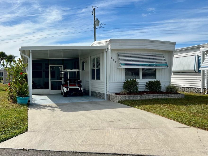 This affordable and nicely decorated 2-bedroom, 2-bath home is located in the desirable 55+ waterfront community of Harbor Cove. With a remarkably low annual lease fee of just $99, this property offers exceptional value and is in the pet section. It features both a screened lanai and an elevated enclosed lanai, offering versatile outdoor living spaces. Attractive furniture and contents are included with sale plus a golf cart for added convenience. Nice open kitchen, dining, living area with some retro wood ceiling beams for added character. Both bedrooms come with built in closets and storage drawers and the bathroom has been nicely remodeled. Newer luxury vinyl flooring is found in most of the home and subfloors were also replaced. There is a good size shed for storage that also houses the washer and dryer. Other updates within the past four years include a renovated bathroom, new carport, updated gutters, and a new vapor barrier. The seller notes that while the roof over the enclosed lanai has been repaired, some ceiling damage remains unaddressed. Harbor Cove residents enjoy access to two heated pools, a hot tub, bocce ball and shuffleboard courts, and optional amenities such as a fitness center, pickleball and tennis courts, craft rooms, and a 90-slip marina with direct access to the Gulf via the Myakka River. This is your chance to embrace affordable living and a vibrant social scene with regularly scheduled organized events. Choose to attend dances, holiday and patio parties, trivia, bingo and card games, picnics, golf cart parades, art classes and more. Join one of the many clubs and start making new friends right away.  Close to shopping, Costco, dining, farmers markets, quality medical services and beautiful area beaches.  Schedule a showing today to take a closer look!