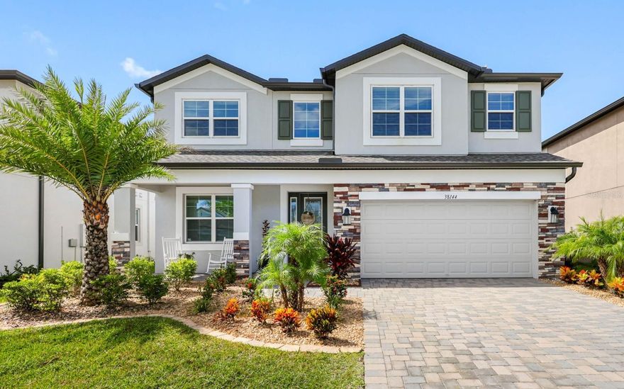 Welcome to the sought-after Cobblestone community in Wesley Chapel! This stunning MI Homes Mira Lago floor plan offers 5 bedrooms, 4 bathrooms, and a versatile bonus room, with a total of 3,761 square feet of thoughtfully designed living space. A unique highlight of this home is the rare dual primary suites - one on the first floor and one on the second - perfect for multigenerational living or hosting guests in comfort and privacy. Step inside to an open-concept layout designed for modern living and effortless entertaining. The expansive great room flows seamlessly into the gourmet kitchen, featuring an extended island, butler’s pantry, stainless steel appliances with a wall-mounted hood, oversized pot sink, quartz countertops, and a stylish tile backsplash. Gather around the electric fireplace in the great room for cozy evenings at home. The downstairs primary suite offers a serene retreat with a spa-inspired bath including a garden tub, walk-in shower, dual quartz vanities, and a spacious walk-in closet. Upstairs, an open bonus room provides a perfect second living area, office, or media space. The upstairs primary suite boasts a private balcony overlooking the conservation area, plus a luxurious bath with dual sinks, quartz counters, garden tub, walk-in shower, and expansive closet space. Three additional bedrooms share a full bath with a tub/shower combination. Additional highlights include: Tile flooring throughout main living areas - Plush carpet in all bedrooms - Inside laundry room with built-in cabinetry - 2-car garage with epoxy floors - Paver driveway for added curb appeal. Enjoy the privacy of east Pasco County while remaining just minutes from major roadways, shopping, dining, and entertainment. Why wait to build? Move in now and start enjoying the lifestyle you deserve!