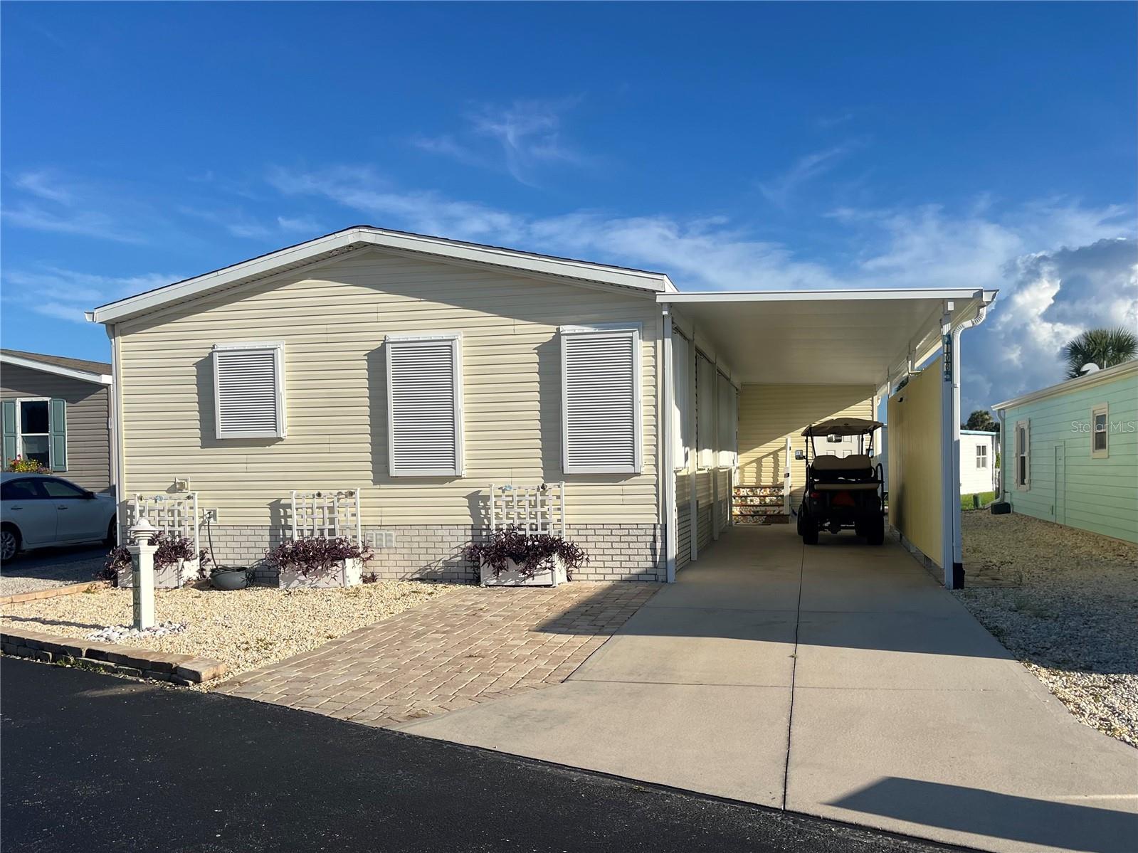 Looking for a larger home at the beach? This elevated 2016 Homes of Merit sits on a high and dry lot and has been built to the highest standards for manufactured homes at the beach. This beautiful Coastal Style Home has 1223 sqft, 2 bedrooms and 1.5 bathrooms and has everything you have been looking for in your beachside paradise! Step into this home and be wowed at the large open floor plan, with high ceilings, easy maintenance vinyl flooring, beautiful kitchen, coffee bar and center island. If you are working from home there is a custom built office with a private screened back porch off of the office space so you can sit outside and enjoy the soft cross coastal breezes while working from home. The outside of the home offers an extra long driveway with plenty of parking under the semi enclosed carport which could easily be made into a garage if needed. There is also a shed at the end of the driveway giving you an abundance of space for that extra needed storage, it is set up with extra insulation, whole house water filter and electricity. You will have peace of mind with the whole house Hurricane shutters and the new A/C and new hot water heater both installed in 2025. This home has a split bedroom plan giving your guests a bit of privacy, it has accessibility size doorways and comes partially furnished.  This wonderful home is offered in Surfside Estates, an active 55+ Manufactured Home Community that is nestled between the Atlantic Ocean and the Intracoastal Waterway. Surfside Estates is a Resident Owned land share Community which means there is no lot rent! When you purchase your home in Surfside Estates you own a share of this beautiful beachside community. The monthly maintenance fee is $180/month and includes wi-fi, internet, cable, yard maintenance, management and use of all the facilities. There is an inground heated/cooled pool, fitness room, library, shuffleboard court and rooftop deck. The Social Club offers many activities to get involved as much or as little as you like. Friday night bingo, men's and lady's cards, pool tables and large screen TV for all your sporting events. Exercise classes and water aerobics. Walk to the beach across the street or ride your bike or golf cart to one of the 2 docks to enjoy fishing or just relax and enjoy the sunsets and the boats and dolphins go by. There is kayak storage, a BBQ Pit and gazebo with a view of the Intracoastal. The quaint neighboring town of Flagler Beach is just a few minutes down the road, where you will find a variety of shops and restaurants to choose from. Just over the bridge you will find shopping, restaurants, hospitals and doctors. Schedule your appointment to see this beautiful home and all this wonderful community has waiting for you to enjoy