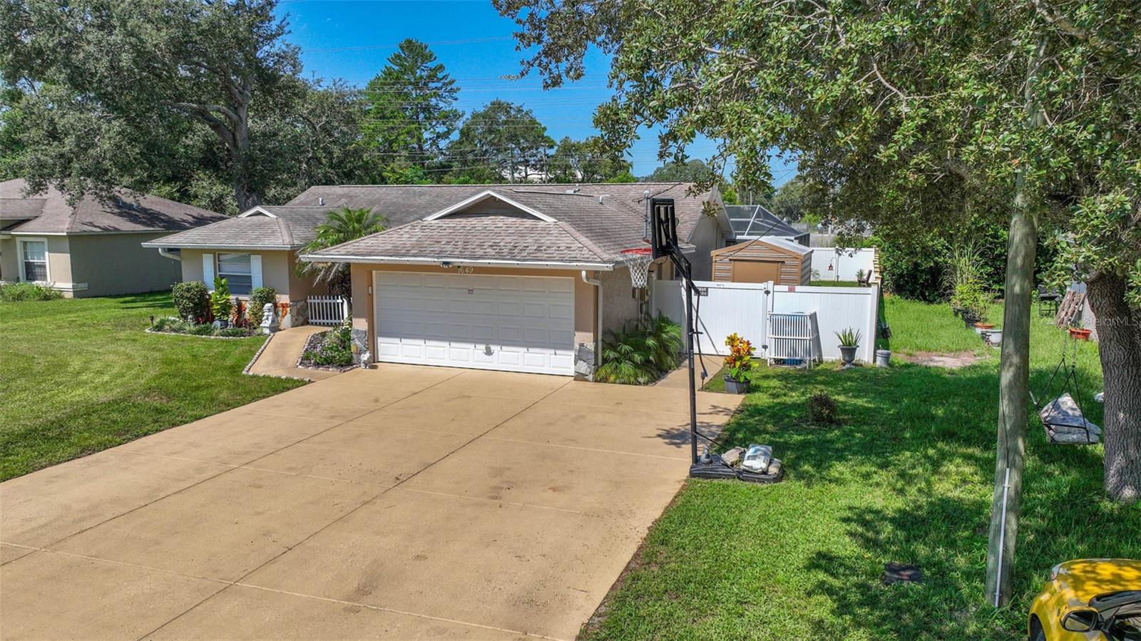 Welcome to this beautifully maintained 4-bedroom, 2-bathroom home with a 2-car garage, perfectly situated in the heart of Spring Hill. This property offers both comfort and convenience with updates throughout. The kitchen and bathrooms have been tastefully renovated, while tile flooring runs seamlessly through the entire home. Enjoy a spacious layout with generously sized bedrooms and plenty of natural light. The exterior is just as impressive with a white PVC-fenced backyard, lush landscaping, and an extended driveway for additional parking. Relax or entertain in your sparkling screened-in pool, finished with diamond Brite . Spacious Covered Lanai. Pavers on Deck and Lanai. Take advantage of the outdoor shed for extra storage. Centrally located near shopping, dining, medical facilities, entertainment, and even the local beach. Easy commute to Orlando & Tampa Bay areas. This home truly has so much to offer! Priced to sell !!