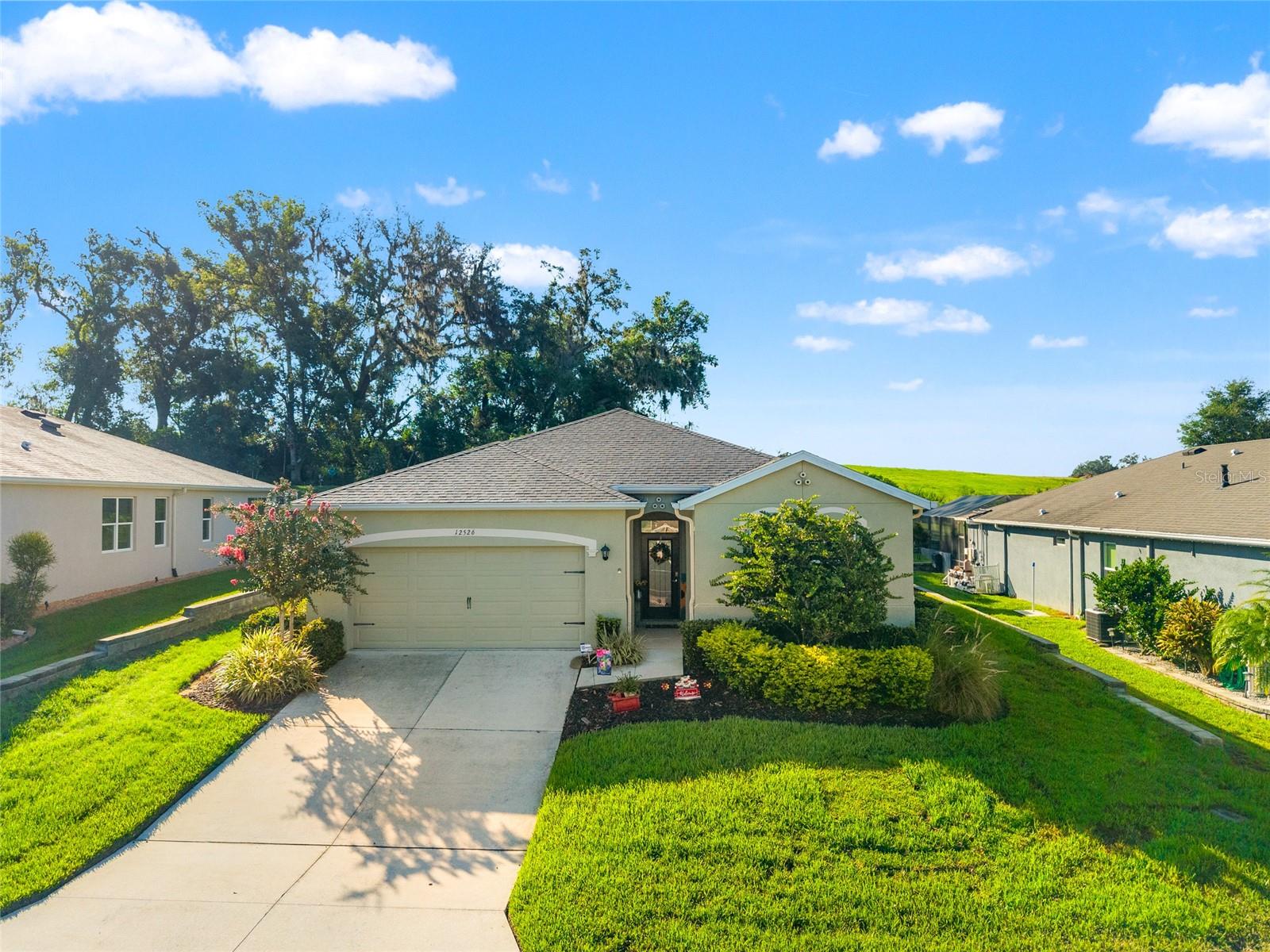 Nestled in the highly sought after Lake Jovita Golf and Country Club, this stunning home offers the perfect blend of elegance, comfort, and resort-style living. From the moment you arrive, you’ll be captivated by the charming curb appeal, beautifully manicured landscaping, and peaceful setting within this gated community. Step inside to discover a spacious, light-filled interior featuring soaring ceilings, an open-concept layout, and timeless finishes designed for both everyday living and entertaining. The heart of the home is the gourmet kitchen, complete with custom cabinetry, granite countertops, and stainless-steel appliances perfect for preparing meals while overlooking the living and dining spaces. The owner’s suite provides a private retreat with a spa like ensuite bathroom, walk-in closet, and serene views of the lush backyard. Additional bedrooms are generously sized, offering comfort and flexibility for guests, family, or a home office.
Outdoors, enjoy your very own Florida oasis. The screened lanai and patio invite you to relax, unwind, and soak in the golf course lifestyle. Whether you’re sipping morning coffee or hosting evening gatherings, this space is made for memories. Living in Lake Jovita means more than just a home it’s a lifestyle. Residents enjoy world class golf courses, tennis courts, fitness facilities, a clubhouse, and a vibrant social calendar, all just minutes from charming downtown Dade City and a short drive to Tampa.