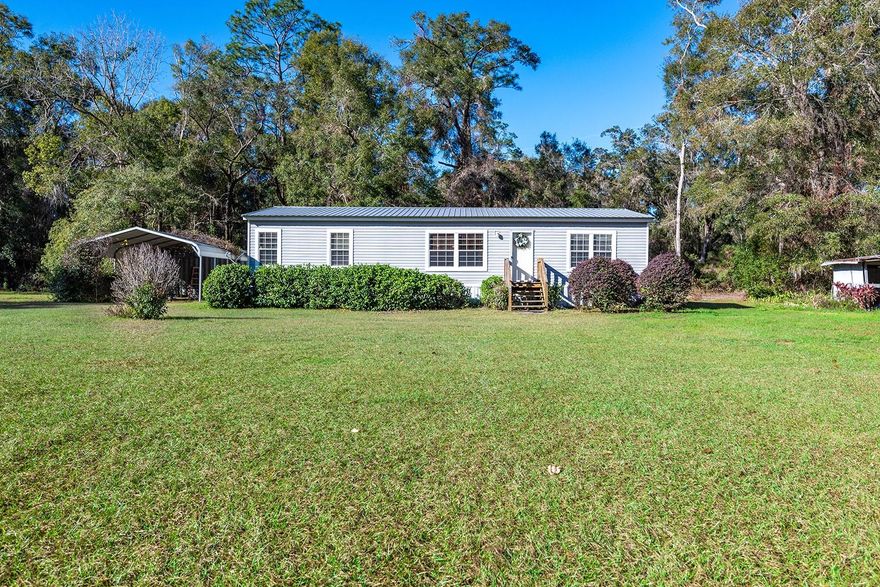 Nestled in the quiet countryside of Newberry, this charming 2-bedroom, 2-bath manufactured home offers the perfect combination of comfort, privacy, and country living. Situated on 10 beautiful acres, this property provides plenty of room to spread out and enjoy the peaceful surroundings while still being conveniently located near local amenities, schools, and outdoor recreation. Inside, the home features an inviting open-concept layout with a spacious living area, a functional kitchen with abundant cabinet storage, and a dining space ideal for everyday living or entertaining guests. The primary suite includes a private ensuite bath, while the additional bedroom offers flexibility for family, visitors, or the potential to create a third bedroom, home office, or hobby space. Step outside and take in all this property has to offer. A covered parking area and storage container provide added convenience, while the expansive acreage opens the door to endless possibilities including gardening, farming, recreational use, or simply enjoying the natural beauty and privacy of your own land. Mature trees and wide-open spaces create a serene setting that truly captures the charm of rural Florida living. Whether you’re searching for a peaceful homestead, a weekend retreat, or a property with room to grow, this Newberry gem is full of potential and ready to welcome you home.