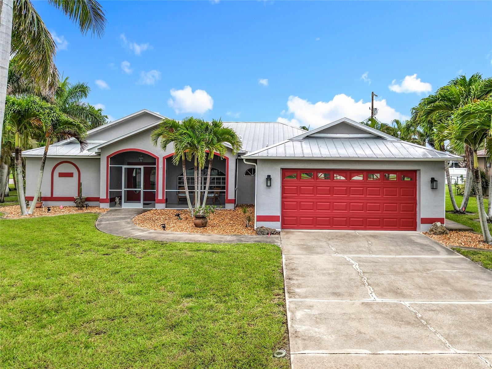 Welcome to this beautifully maintained 3-bedroom, 2-bath pool home offering just under 2,000 sq ft of comfortable living space on an oversized corner lot in a X flood zone! The desirable split floor plan provides privacy and flexibility, featuring an extra-large family room, formal living and dining areas, and a spacious kitchen island perfect for entertaining. Step outside to your private backyard oasis with an oversized, solar-heated pool, surrounded by lush tropical landscaping and an OVERSIZED screened lanai with new screens replaced in 2025. The exterior was freshly painted just 2 years ago, with an 8-year-old metal roof ensures long-term durability and peace of mind. New irrigation system installed 2024! Newer hot water heater too! A 2-car garage offers plenty of storage and convenience. This home is move-in ready (offered furnished if desired) and perfectly located in the heart of Cape Coral — offering the ideal Florida lifestyle