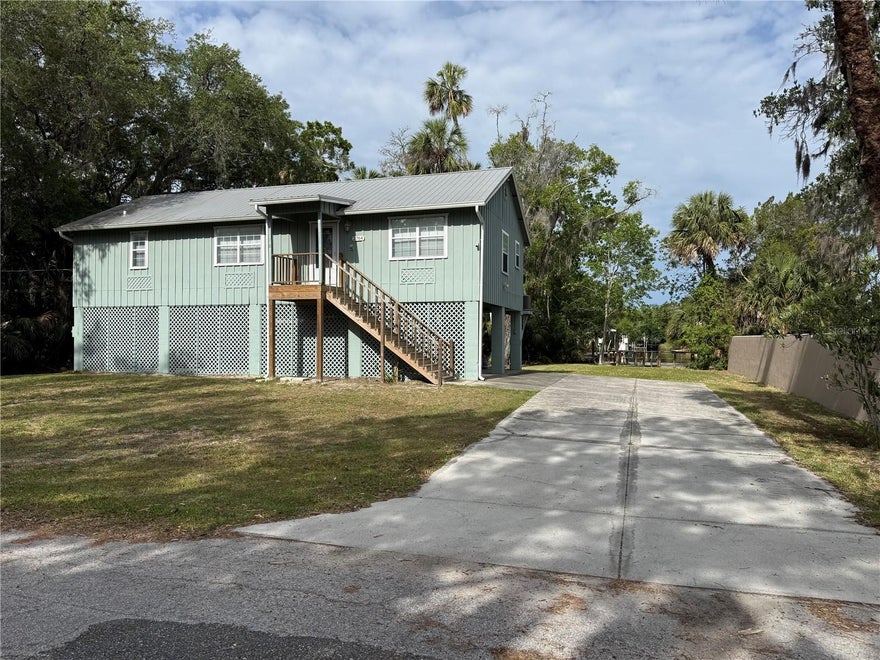 Tucked at the end of a freshwater canal just east of the Salt River, with access to Crystal River, this charming 2BR/2BA stilt home is a nature lover's dream. Whether you're casting a line, launching a kayak, or heading out by boat, the canal is your private gateway to some of Florida's most celebrated waterways. A well-constructed dock with composite decking makes water access a breeze, while the attractive stone seawall adds both function and curb appeal.
The home itself offers 1,248 sq. ft. of heated living space on the second level, featuring 2 bedrooms and 2 baths in a bright, well-maintained interior. Warm tongue-and-groove wood cathedral ceilings give the main living area a cozy coastal character, complemented by durable laminate flooring throughout (tile in the baths and laundry).  A large, screened patio and open porch let you enjoy the outdoors in comfort, while the partially enclosed lower level provides a convenient carport and extra storage. No VRBO restrictions here. HVAC replaced in 2023.