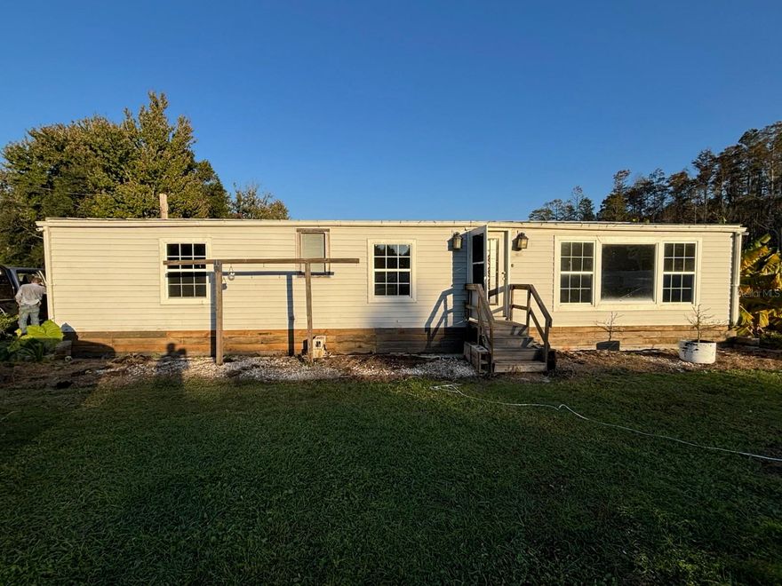 NO HOA Country living but close to Posner Park, Disney, Celebration, Champions Gate--everything you want!  This wonderfully updated manufactured home sits on almost 6 acres--plenty of room for your large equipment, vehicles, boats, RVs, and toys!  And with NO HOA, it will be worry-free living!  The many updates you will notice are the metal roof and the AC (Goodman 3 Ton heat pump and all new duct work) that have been been replaced in the last 2 years, a new well was dug 6 years ago, new siding and Dupont Tuff-R insulation added to entire exterior, new decorative skirting, the gorgeous vinyl stockade fence with double gates, and the septic tank was pumped and had risers installed 2 years ago.  Additional updates to notice are the enclosed porch in the back, all new laminate flooring throughout, and a beautifully remodeled kitchen.  There is even a chicken coop--just add chickens! This home is truly ready to move in and waits for you to make it your own. Schedule a showing, you will not be disappointed!