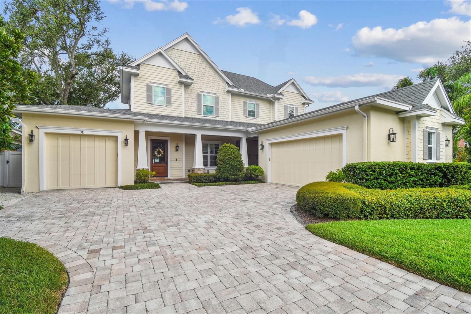 Welcome to this stunning Craftsman-style estate in the highly sought-after Golfview neighborhood of South Tampa. This meticulously designed 5-bed, 4-bath home offers over 4,200 square feet of heated living space and more than 1,100 sq. ft. of covered outdoor areas. Built in 2016 on a 75x100 lot in Flood Zone X, the home features a split 3-car garage with ample guest parking. From the moment you arrive, the home makes a grand impression with its covered front porch, wooden staircase, paneled walls, and abundant natural light. Inside, you'll find hurricane-impact sliding glass doors and windows, rich crown molding, coffered ceilings, and custom light fixtures throughout. The formal dining room sets a refined tone, while the dry bar and arched entryway lead you into the heart of the home: an open-concept kitchen, breakfast nook, and great room designed for both everyday living and entertaining. The oversized island is the centerpiece of the space, and customized with Thermador appliances, a walk-in pantry, built-in butler’s pantry/wet bar, and a large mudroom/laundry room with sink and ample storage. The private first-floor primary suite is a serene retreat with vaulted ceilings, paneled walls, and direct access to the pool and lanai. Its spa-like bath includes a walk-in glass shower with dual shower heads, a freestanding soaking tub, dual vanities with storage, and a spacious walk-in closet. A second first-floor bedroom and full bathroom offers flexibility as a guest room or dedicated office. Upstairs, you'll find three generously sized bedrooms—each with walk-in closets and custom lighting—two full bathrooms, and a versatile loft area perfect for play, study, or relaxation. Attic access is available through the mechanical room for additional storage. Step outside to discover the ultimate outdoor lounge—virtually hidden from the rest of the house and other outdoor living spaces. Complete with a cozy gas fireplace, large built-in TV, stained wood ceilings, and ceiling fans, it’s the perfect setting for gameday gatherings or relaxing movie nights. The expansive backyard lanai features travertine decking, a gas feed and vent ready for your dream outdoor kitchen, and a 392-square-foot in-ground concrete pool (installed in 2017) surrounded by vinyl fencing and a grassy play area. Open space behind the property offers tranquil views of the ever-changing sky, adding to the sense of privacy and serenity. Located just minutes from top-rated restaurants, shopping, Palma Ceia Golf and Country Club, and only half a mile from Plant High School this home is a rare blend of craftsmanship, comfort, and coastal charm. Schedule your private showing today and experience the lifestyle you’ve been dreaming of.
