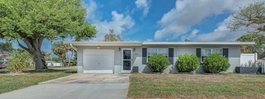 This house comes with a REDUCED RATE as low as 5.375% (APR 5.875%) as of 03/21/2026 through List & Lock™. This is a seller paid rate-buydown that reduces the buyer’s interest rate and monthly payment. Terms apply, see disclosures for more information. Beautifully upgraded 2-bedroom coastal-inspired home on an oversized corner lot in fast-growing Palmetto. Major updates completed in 2020 include new A/C, Water Heater, updated ductwork completed 2025, and system improvements, plus a new roof in 2024. The bright interior offers natural light, warm LVP wood flooring, crown molding, premium window treatments, a charming beaded accent wall, wood cabinetry, and timeless Old Florida bungalow character. Outside, enjoy a fully fenced white picket yard, a spacious patio, and a huge backyard centered around a majestic mature oak tree — the perfect setting for entertaining or relaxing. The 1-car garage adds flexibility for storage or future use. Located just moments from Emerson Point Preserve, a coastal preserve on Snead Island between the Manatee River and Terra Ceia Bay, and near marinas, fishing, waterfront dining, shopping, and commuter routes including US-19, US-41, and I-75. Per seller, home stayed high and dry with no flooding or storm damage during Hurricanes Helene or Milton. Furnishings available for sale.