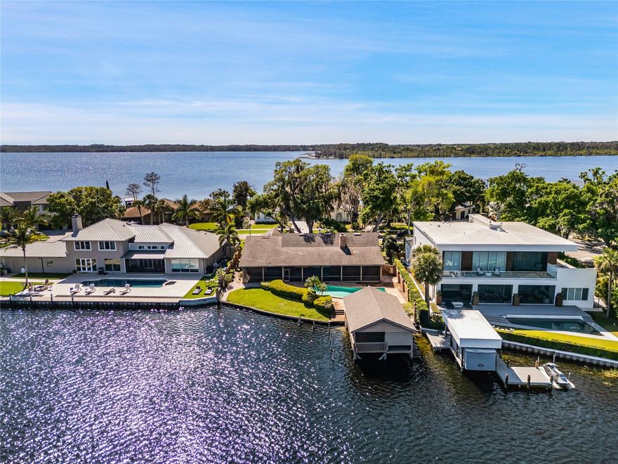 Lakefront opportunity in gated Bay Point in Bay Hill! One of the last chances to build a New  lakefront home OR Renovate in this exclusive & gated, Southwest Orlando community! Conveniently located on the famed Butler Chain of Lakes, this 1981 ranch-style brick home includes a rare boat house, dock, & overlooks open waters, facing East in the rear, for enjoyable sunsets! The custom home is a 3/2.5, 2,651 Sq. Ft. under air, with fireplace, Great room, large covered rear porch, and open pool. The Highest & Best use is a complete REMODEL, which has been done with numerous homes, in this small 40-home community. OR, build NEW.  Sold As-Is, with right to inspect. HOA rules and regulations are strictly enforced including setbacks, architectural approval, and more. NOTE: Seller a Permit application in with Orange County to remove the old boathouse and dock, and another permit application into Orange County for a New Seawall to follow; both should be approved and in progress by February 2025. Owner Financing available on a short-term basis - contact George for details.