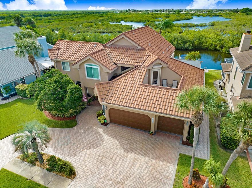 Magnificent waterfront oasis in Sykes Cove. You'll be enchanted by the sheer elegance and luxury of this sprawling pool home. Nestled in a picturesque setting, this is more than a home; it is a lifestyle. Wake up to breathtaking water views, sip coffee poolside, enjoy sunsets & nature views in your private paradise, plus watch launches from the front balcony. 5 spacious bedrooms for your growing family... or for home offices in today's work-from-home culture. Designer kitchen w/island, breakfast nook, bar, desk & walk-in pantry. Master suite boasts private balcony, his & hers walk-in closets, slipper spa tub, & more. PLUS a 3-CAR garage, newer seawall, boat lift, circular paver driveway, metal roof, hurricane shutters. The epitome of luxury living... make this dream home yours!