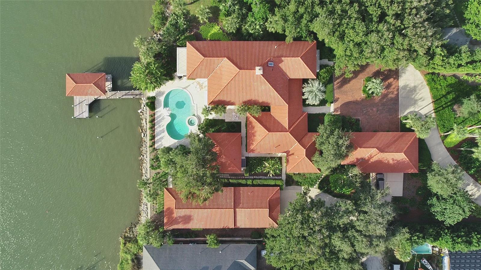 This island beachside property consists of two adjoining but separately deeded physical addresses each located at 602 North Peninsula Drive and 520 North Indian River Road with access from Due East Avenue in beautiful New Smyrna Beach. Both properties are situated upon an approximately 1.2 acre parcel of land that is wooded and professionally landscaped providing secluded privacy and direct deep-water river access to the ICW just beyond the 160 LF fully rip-rapped seawall that protects the entire property’s western waterfront edge. A beautiful 6,842 SF main home with a separate 594 SF detached pool cabana architected by Will Jerome Miller,whose design features have allowed for exceptional scenic vistas and unobstructed views of the ICW. Windows and doors throughout the home are designed and manufactured by Pella with nicely finished treatments. Large gourmet kitchen with an expansive walk-in pantry,large living room,sitting area with a large fireplace, and 4 large bedrooms with 5 bathrooms. The guest, master, and pool suite bathrooms are adorned in classic marble design by Terry Fuqua Marble. The home encompasses custom mahogany cabinetry by Austrian craftsman Ziggy Bauer with multiple storage areas and closet space at every turn. The 2nd floor consists of approximately 2000SF master suite with a near 180-degree view of the Intracoastal, separate private study/library and outdoor deck access, bathroom, walk in closet, a “SteamMist” steam room and shower area along with a gym overlooking the front garden. Over-sized 3 car garage contains a 100Amp Tesla charging station, workshop area with plenty of storage. Patio pool deck area is finished with a wet bar and large kidney shaped pool with spill-over spa and direct dock access to a covered 30LF by 18LF boathouse with Monier tile roof covering, fully equipped with a motorized lift system. Additionally, there are two Ace Power Hoist lifting davits upon the dock where there is deep water at the dock fronting the ICW. ;Water: City