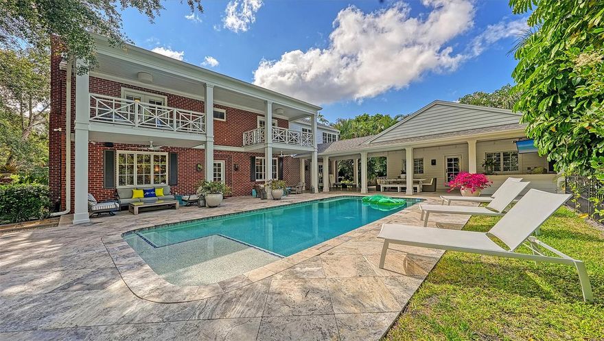 Perfectly located in the picturesque West of the Trail enclave of Bay View Heights – between Cherokee Park and Harbor Acres – this thoughtfully renovated traditional masterpiece blends classic original details and charm with modern conveniences and stylish aesthetics. The 3 bedroom/3.5 bath main home, 2 bedroom/1 bath pool house, and 1 bedroom casita provide the ultimate flexibility for different living arrangements, all in an in-town, yet private compound. Just blocks from Sarasota Bay, the enchanting 1938-built main residence has undergone several renovations over the years, most recently with the direction of Kurt Lucas and Ashley Langer of JKL Design Group, adding sophisticated appointments and a chic vibe to enhance the warmth of the gracious home. An inviting front porch opens to a foyer that flows into the elegant living room, showcasing pegged maple flooring, intricately carved crown molding and a gas fireplace. The gorgeous gourmet kitchen boasts Carrara marble countertops and backsplash, center island, new Wolf gas range with a pot filler, built-in Miele coffee station and Rohl farmhouse sink with instant-hot feature. The breakfast nook overlooking the pool has integrated banquette seating and custom built-ins. A new elevator provides easy access to the expanded second-floor primary suite, which includes a new 14’ x 13' custom walk-in closet with center dressing island, additional dressing room/closet with custom built-ins and a second laundry room. The en-suite bath features a walk-in shower with marble tile and floor, free-standing tub, and a large linen closet with custom shelving. French doors from the bedroom open to a private covered balcony overlooking the pool, where you can savor coastal breezes and a nightcap under the stars. The second bedroom could serve as an additional primary suite, with a covered pool-view balcony, wood-burning fireplace, en-suite bath and large walk-in closet with built-ins, while the third bedroom has been transformed into a multi-functional space with custom bunk beds – a queen bed on the bottom and two twin beds above. An idyllic private sanctuary awaits in the tranquil outdoor living space – a cherished setting surrounded by lush, mature landscaping for complete privacy that beckons relaxing and entertaining. Surrounded by stately oaks, impressive magnolias, royal palms, a gorgeous 32’ x 15’ open-air, heated saltwater pool is the centerpiece, with ample space for a children’s play area and frolicking pets. Travertine pavers extend from the pool deck to an expansive covered lanai offering an outdoor kitchen with a new grill, refrigerator and ice maker, and motorized retractable screens, making it a fabulous spot for alfresco meals and intimate gatherings. Overnight guests will be right at home in the 2014-built two-bedroom, one-bath pool house, and a well-appointed casita above the two-car garage offers a flexible living space that can be rented separately from the main residence. Escape to simpler times while swinging beneath oaks, relaxing on the front porch or lounging by the pool in this charming, private compound close to shopping, dining, and Morton’s Gourmet Market in delightful Southside Village, and just a short drive to downtown Sarasota and world-famous beaches.