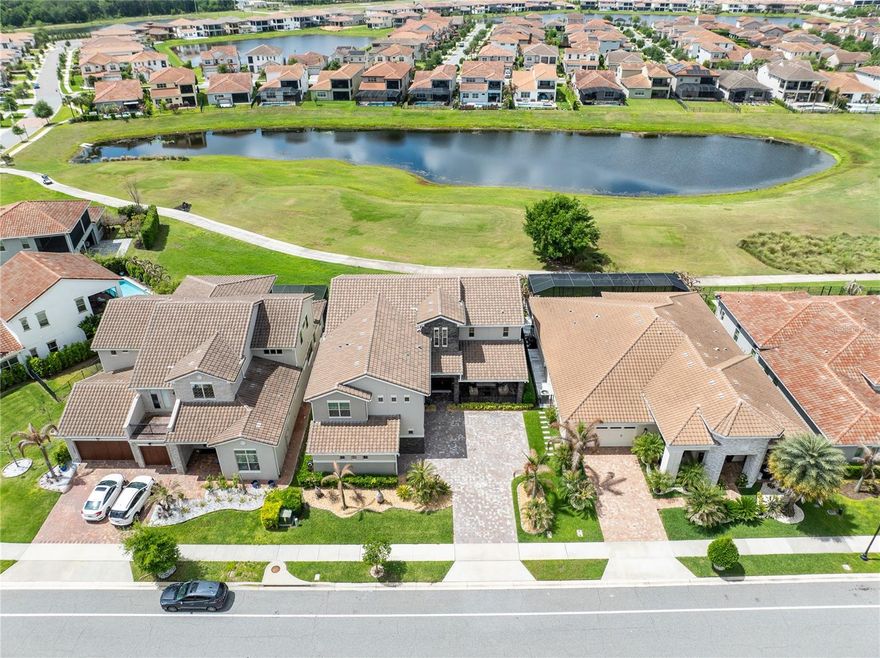 Perched along the 15th fairway of the coveted Eagle Creek Golf Course, this stunning Jones Homes "Southern Dunes" build offers an exceptionally rare combination of refined luxury, thoughtful design, and natural beauty. Built in 2021 and just minutes from Lake Nona's Medical City, this 4,600 square foot masterpiece delivers five bedrooms, five full bathrooms, and a three-car garage in one of Orlando's most desirable gated communities.
Arrival sets the tone immediately. Meticulously manicured landscaping, swaying palms, and ambient night lighting frame a home that commands attention before you ever step inside. A covered front patio invites morning coffee and quiet reflection, while the seamless flow between front and rear glass sliding doors creates the kind of indoor/outdoor living that Florida was made for.
The soaring foyer opens to a breathtaking open-concept living, dining, and kitchen space designed for both everyday living and effortless entertaining. At the heart of it all, the gourmet kitchen features a sprawling island topped with a single-slab quartz countertop, custom cabinetry with under-cabinet lighting, a pot filler, upgraded appliances, and a generous walk-in pantry. The adjoining dining area comfortably accommodates large gatherings, all while overlooking the expansive living space and the lush fairway views beyond.
The main floor also offers a private guest ensuite with a walk-in closet, a dedicated home office with built-in shelving, a full bathroom with a walk-in shower, and a charming under-stair retreat for the four-legged members of the family.
Upstairs, an open loft provides a versatile second living space before giving way to the owner's suite. The primary bedroom is a true sanctuary, anchored by a spa-inspired ensuite featuring a freestanding soaker tub, dual-sink vanity, and an oversized shower with dual showerheads, a rainfall fixture, and a built-in bench. The custom walk-in closet connects directly to a dedicated laundry suite complete with a sink, abundant cabinetry, and hookups for dual washer and dryer sets. Three additional bedrooms complete the upper level, including a second guest ensuite.
The home's finish level throughout is exceptional. Wide-plank ceramic tile and engineered hardwood floors run throughout (no carpet, anywhere), complemented by quartz countertops, decorative ceiling beams, crown molding, upgraded lighting, and additional recessed canister lighting across every level.
And then there are the views. From the main-level lanai or the upper balcony, sweeping vistas of the fairway, shimmering water features, and breathtaking western sunsets make this far more than a home. It's a lifestyle.