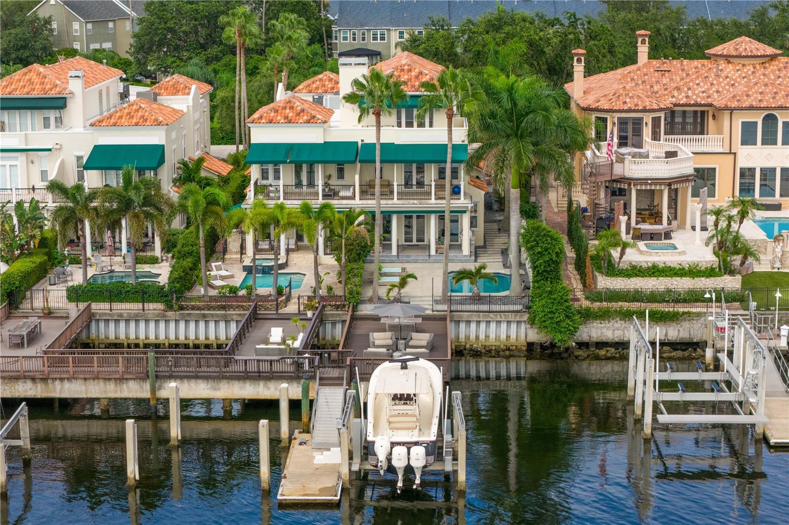 Welcome home to the pinnacle of casual sophistication on Harbour Island, where a completely redesigned three-level waterfront residence redefines luxury living in Tampa Bay. Framed by the artistry of SOL Design Architecture, this home greets you with a front entry hallway that effortlessly unfolds into a luminous great room. Towering windows capture daily sunsets over the water, while seamless sightlines invite the outdoors in, setting the stage for both intimate evenings and grand gatherings. Step into the chef’s kitchen, where Wolf and Sub-Zero appliances stand ready beneath custom millwork and expansive storage. The great room flows to a cantilevered deck suspended above the water and adds an additional nearly 600 sf of outdoor living, complete with a private pool, spa, covered lanai, and built-in Wolfe outdoor kitchen. Whether you’re hosting sunset cocktails or slipping into your boat for a day on the water, every moment here feels both private and jubilant. On the first floor, discover a versatile bedroom suite—ideal as a guest retreat, home office, or private workout studio—with its own ensuite bath. A solid steel and wood floating staircase sweeps you upward to a dedicated media and game room, where a wet bar and second-floor balcony offer panoramic water vistas. Two additional bedrooms share a nicely appointed full bath with double vanities and oversized tub and shower with chic finishes and beautiful pendant lights. Ascend to the third floor and enter an entire wing devoted to the primary suite, a five-star sanctuary overlooking the glistening waters. The spa-inspired bathroom flows directly into the bedroom, delivering uninterrupted water views from the oversized soaking tub to the glass doors. An adjacent custom closet provides an abundance of storage, ensuring that form and function unite in perfect harmony. The location of this residence is superior to others within the neighborhood providing exceptional privacy and expansive views, unlike others in the neighborhood, as it abuts the prestigious Pointe neighborhood. Harbour Island’s 24-hour guarded gates ensure serenity, yet you’re mere steps from Tampa’s vibrant Riverwalk, Bayshore Boulevard, Water Street, and the city’s premier arts and dining districts. Commuters appreciate quick access to I-275, the Lee Roy Selmon Expressway, and Tampa International Airport, making every aspect of daily life effortless. Move right in and begin living the waterfront dream you’ve always imagined—sunsets, sailing, and sophisticated entertaining await.
