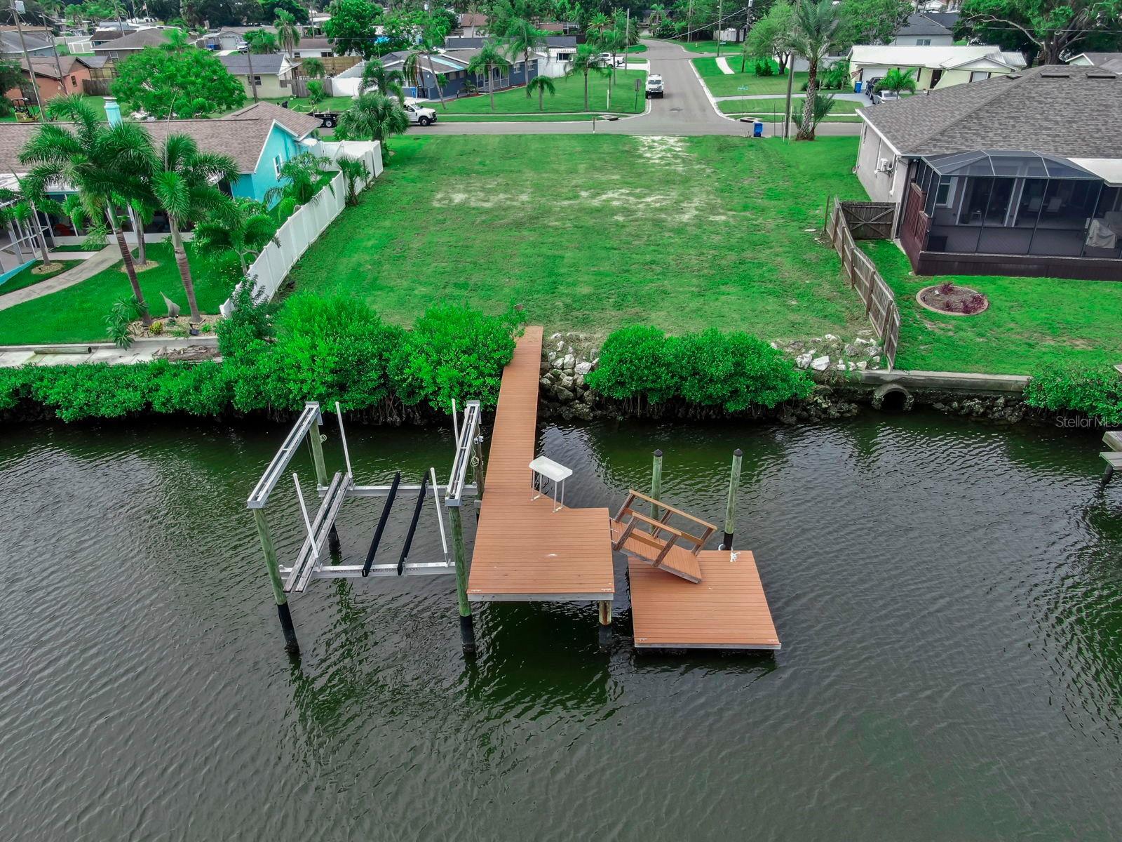Build Your Dream Waterfront Home & Embrace the Florida Boating Lifestyle! Welcome to Apollo Beach, where your vision of the perfect coastal lifestyle can finally come to life with NO HOA and NO CDD fees to limit your Home Dreams! This prime waterfront lot boasts 77 feet of wide, deep water canal frontage with direct access to Tampa Bay. The durable composite dock is equipped with a 10,000 lb boat lift for you to enjoy the boating lifestyle right away during your home's construction! The dock also features an additional floating dock perfect for kayaking, paddleboarding, and fishing! There is a convenient fish cleaning station when you reel in the catch of the day! There is plenty of room to build a generous outdoor pool and lanai to have your own private oasis at home making it feel like vacation every day! If you prefer dining over cooking, take a short boat cruise over to waterfront dock able restaurants Finn's or Circle's in Apollo Beach. Impact Fees are already paid for a 2,169 sq ft home, saving you thousands and fast-tracking your build. Don't miss your chance to design your coastal lifestyle in one of Tampa Bay's most desirable waterfront communities - Apollo Beach!
