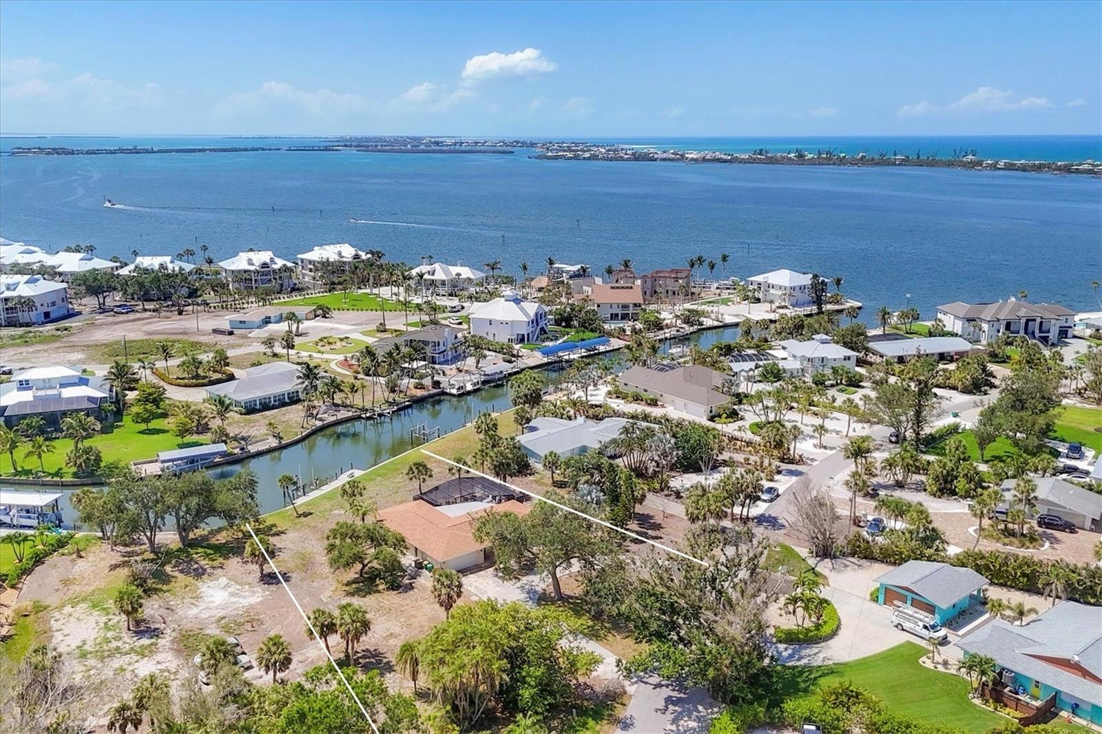 An incredible Cape Haze home for boaters and fisherman, with 105 feet of deep-water canal frontage, brand new composite dock with a new robust 13,000 lb Deco boat lift, no bridges, and only about 600 feet to the Intracoastal Waterway. Highly sought after location in Cape Haze, the home is on the very southern canal of the neighborhood, which means that boaters are instantly in the world-class fishing waters of Charlotte Harbor or to Gasparilla Pass and the Gulf of Mexico. New concrete seawall and a wide section of the canal allows for very large vessels to easily navigate and dock at the property. A superb location, the home sits on a .68 acre lot, tucked in a secluded area of the historic Vanderbilt developed neighborhood of Cape Haze the streets are lined with towering banyan trees. The classic 1960's home is in phenomenal like-new condition after a complete 2025 renovation inside and out. It beautifully blends some of its best retro features like gorgeous terrazzo flooring with endless new features from the 2025 project that includes a new roof, beautiful new kitchen, bathrooms, LVP in guest rooms, pool cage, swimming pool tile and resurface, new pool heater, all appliances, new water heater, AC and duct work, and a new septic system. The stunning bathrooms offer tiled showers, designer vanities, new plumbing fixtures, and framed mirrors. The kitchen now has new custom wood cabinetry, quartz stone counter tops, stainless steel appliances, and new plumbing fixtures. The Cape Haze Property Owners Association includes a private dock and beach access on Don Pedro Island. The home is just minutes by car or boat to historic Boca Grande, miles of pristine sandy beaches, essential shopping, fine dining, private Coral Creek Jetport, private and public golf courses and several full-service marinas.