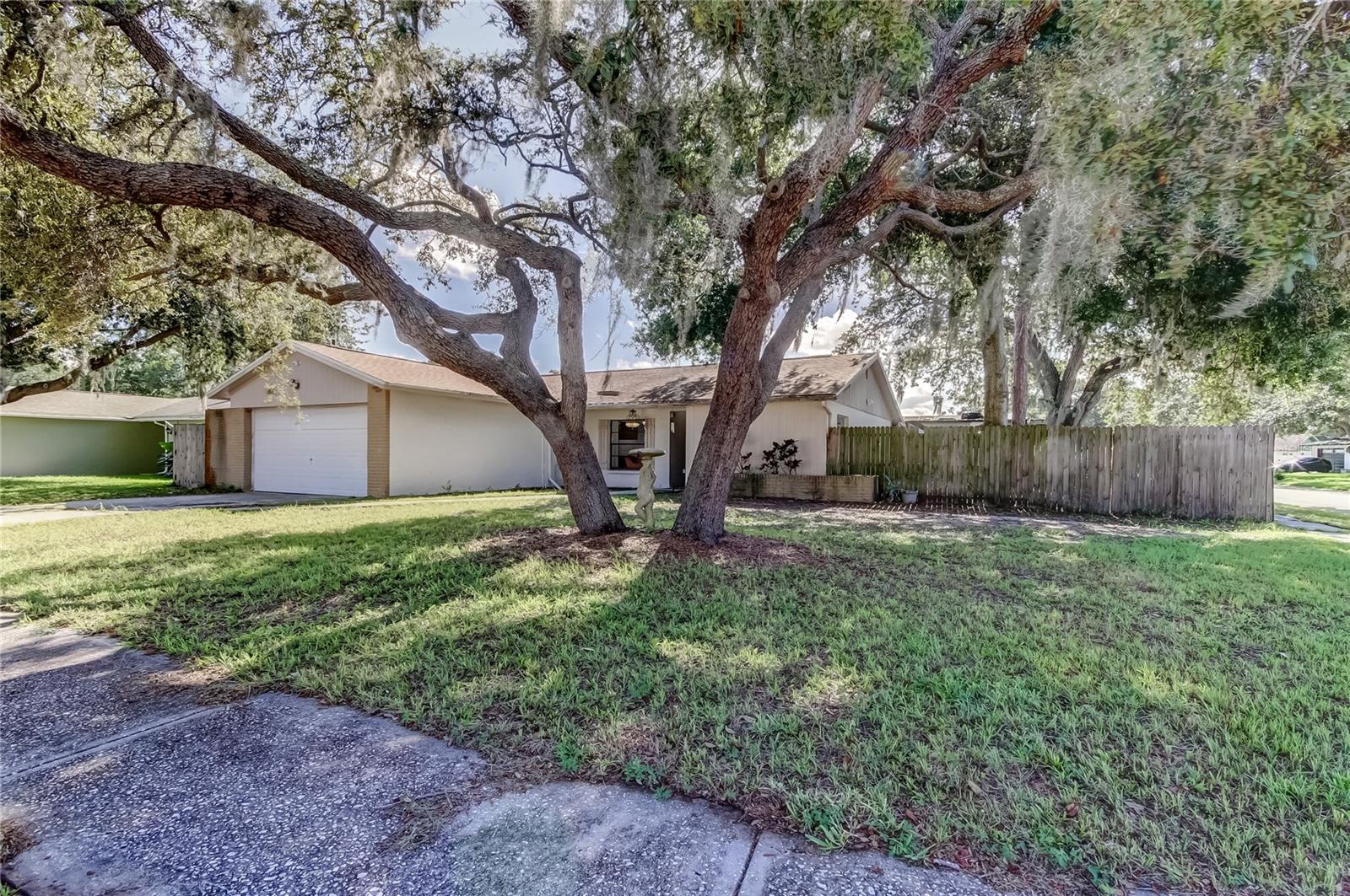 Sugarwood Grove beautifully refreshed 4 bedroom, 2 bathroom, 2 car garage pool home with a covered, screened lanai. Excellent central Tampa, Carrollwood community zoned for some of the highest rated schools in Hillsborough County: Northwest Elementary School, Smith Middle School and Sickles High School. The home features a bright, open layout with brand-new luxury vinyl plank flooring and fresh, neutral interior paint throughout, new modern lighting, and bathroom updates. Your kitchen has stainless appliances with plenty of countertops and cabinet space, opens up to the dining room and living room with a stone, wood burning fireplace and views of the pool. An exciting opportunity to customize and design your dream cooking space awaits. The primary bedroom includes a private en-suite bathroom and generous closet space. Split bedroom floor plan with one bedroom across from the primary bedroom. The two additional bedrooms are on the opposite side of the living quarters with the second bathroom in the adjoining hallway. Step outside to enjoy Florida living at its best! A large covered, screened lanai with two exterior doors overlooks the in-ground pool, ready for you to create your own peaceful and private outdoor retreat. This move-in ready home sits on an oversized corner lot with no HOA or CDD fees. Mature landscaping, fully fenced backyard with two front gates and an extra-wide side gate perfect for storing a boat, trailer, or RV. Shopping and dining destinations are so close including Citrus Park Mall and Tampa International Mall. Many places of worship are also near. Located just minutes from the Veterans Expressway, this home provides quick access to the Tampa International Airport, the Downtown Tampa and Westshore Business Districts, Florida's world famous sandy beaches: Clearwater Beach, St. Pete Beach, Madeira Beach, St. John's Pass and more making weekend getaways effortless. This home offers an ideal blend of comfort, convenience, and location whether you’re relaxing by the pool, shopping, dining or enjoying all the fun that goes with living in Sunny Florida. What's not to love?!? Call now for your private showing.
