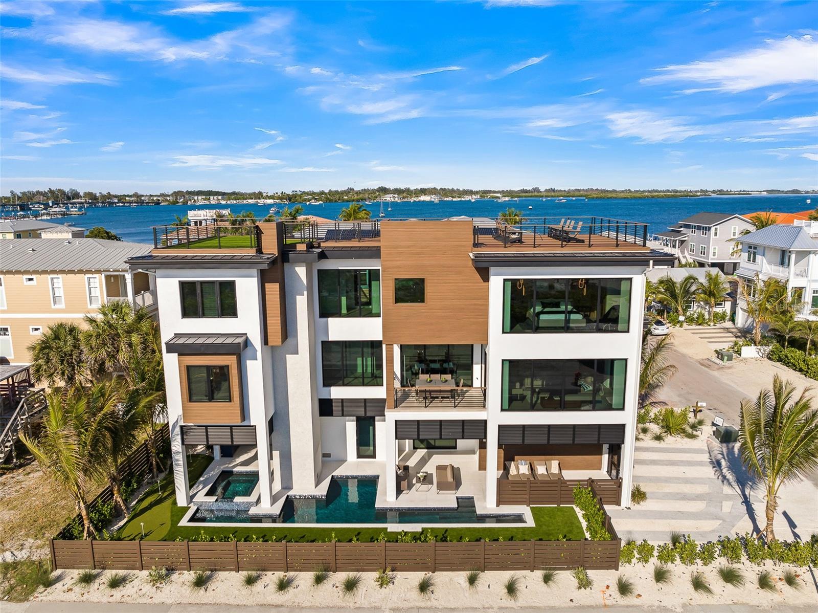 Experience unparalleled luxury in this brand-new home with full views of the Gulf of Mexico’s pristine beaches. Located on Anna Maria Island, this exquisite property is designed to offer you a spectacular living experience, with almost every room boasting panoramic beach views. This six-bedroom, five-and-a-half bathroom turnkey furnished home boasts over 3,100 sq ft of living space. Inside you will discover an interior meticulously crafted for comfort and style with no detail overlooked. The living area takes full advantage of the views and is the perfect spot for relaxation. The impressive rooftop deck is the crown jewel of the home. You can soak in the panoramic beach views while enjoying ample seating, an outdoor kitchen, and a cozy fire pit perfect for starlit evenings. Whether you’re lounging with a book or hosting a sunset dinner, this space promises unforgettable memories. Step inside to discover an interior meticulously crafted for comfort and style. The progressive seating area features high-end sofas and a large television, creating a perfect spot for relaxation and entertainment. The gourmet kitchen is equipped with top-of-the-line appliances and culinary essentials, complemented by barstool seating and an indoor formal dining table. For those who love al fresco dining, the balcony provides a serene setting with a dining table overlooking the Gulf. The main bedroom is a sanctuary of tranquility, offering a premium King-sized bed and a spa-like ensuite bathroom with a double vanity, walk-in shower, and standalone tub. Each guest room is equally luxurious, featuring ample storage space. The two King guest rooms come with private ensuite bathrooms, while the Queen bedroom shares a hall bathroom with a full shower with the sixth bedroom, which is charmingly appointed with a delightful bunk bed. Beyond the stunning interiors, this home boasts an outdoor oasis perfect for soaking up the Florida sunshine. Enjoy the unique pool with an in-ground spa, and practice your putting skills on the poolside putting green. When you’re ready to explore, take advantage of the free trolley, rent a golf cart, or stroll around to immerse yourself in the local atmosphere. Indulge in the mesmerizing beauty of the beach right across the street, and when adventure calls, explore the vibrant local scene with ease. Located in Bradenton Beach you are steps away from amazing dining and shopping. This home truly stands as the crown jewel of Anna Maria Island, offering a lifestyle of elegance and relaxation with breathtaking beach views from almost every room. Don’t miss your chance to own this piece of paradise.
