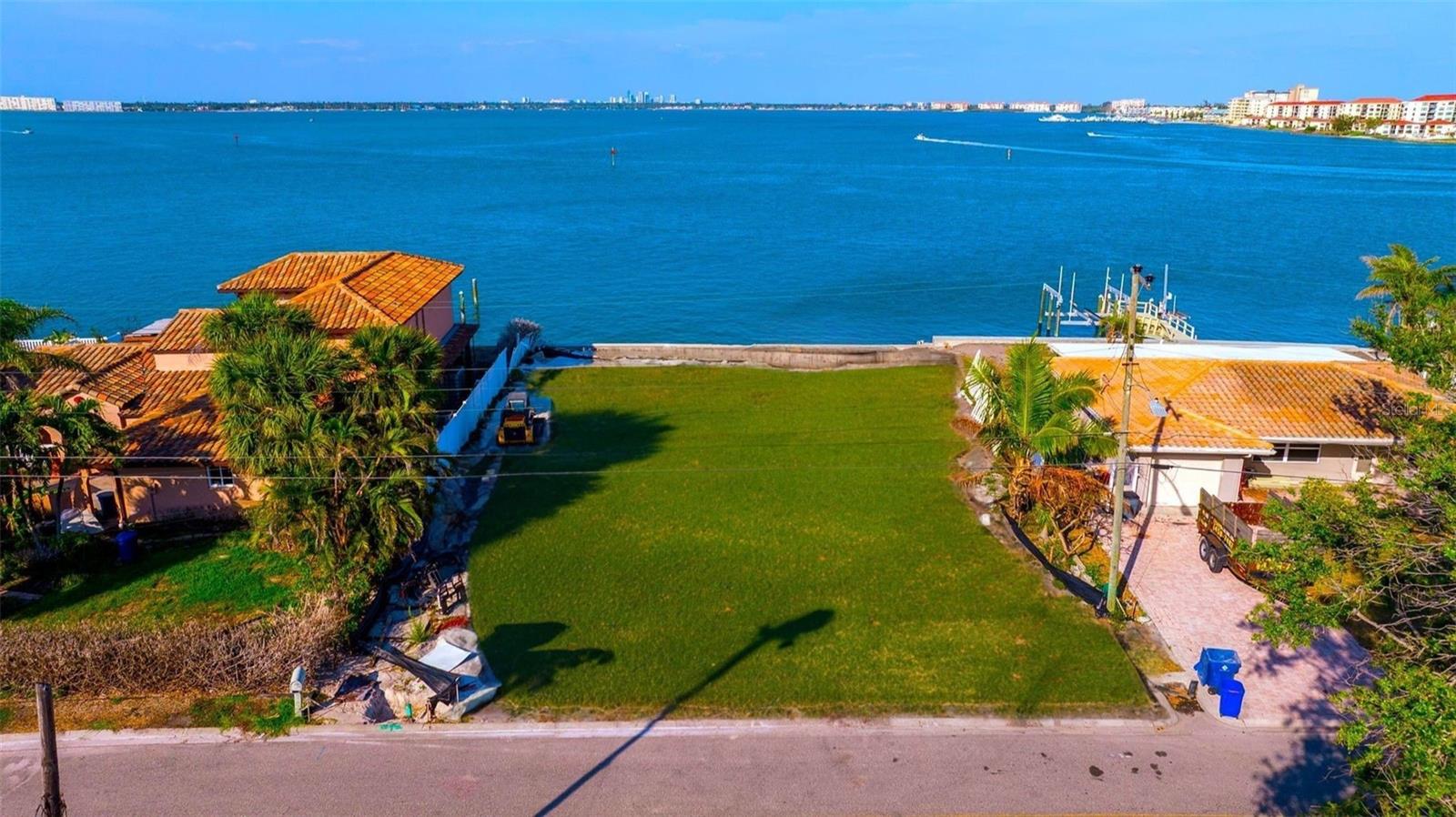 Create your own oasis with breathtaking expansive water views. This is your opportunity to design the ideal residence on an extraordinary parcel situated on the highly sought-after Belle Vista Island. Whether you envision a contemporary masterpiece or a charming coastal retreat, this parcel offers the perfect backdrop for your vision. In addition to deep water access, the backyard boasts magnificent views of the wide open Boca Ciega Bay, featuring an impressive 85 feet of water frontage. The lot offers stunning vistas of Tropicana Stadium, Tierra Verde, Gulfport, and a sweeping 180° panorama of the Bay and main channel. As part of this exclusive community, you’ll enjoy not only the natural beauty that surrounds you but also the convenience of nearby amenities. From fine dining to boutique shopping, everything you need is just a short drive away. Immerse yourself in this vibrant community, enjoy leisurely strolls along the shoreline, and take advantage of the close proximity to nearby beaches, including Pass-a-Grille, Treasure Island, and St. Pete Beach. This property represents a remarkable opportunity to build your dream home in a picturesque setting, serving as a blank canvas for your creative aspirations. A new seawall valued at $100,000 is included with the purchase. The owner, who is also a luxury custom home builder, is ready to assist you. Bring your plans or collaborate with the builder to design your perfect sanctuary.