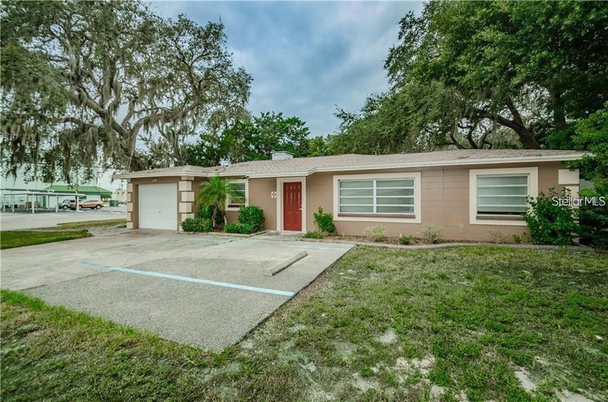 Discover this unique corner-lot property offering the comfort of a home with the versatility of an office. Featuring two private offices, a spacious shared workspace or conference area, a welcoming reception/waiting area, and a full kitchen, this layout is ideal for professional, medical, or creative use.  The open concept connects the front living and kitchen areas, creating a bright, collaborative atmosphere. Toward the back, you’ll find an additional open bonus room—perfect for a larger shared office, meeting space, or client lounge—along with a screened-in porch for breaks or informal gatherings.  Recent updates include a new roof (2015), central A/C (2020), fresh interior paint, wood-look tile flooring throughout, and a beautifully remodeled bathroom. The corner lot provides excellent visibility and ample parking, including extra spaces for staff or visitors.  Located just minutes from the City of New Port Richey Recreation Center and downtown’s restaurants, shops, and historic district, this property sits in a golf-cart-friendly area—ideal for accessibility and local charm.  Whether you’re seeking a professional workspace with a comfortable feel or a strategically located investment, this property offers flexibility, visibility, and convenience in the heart of New Port Richey.