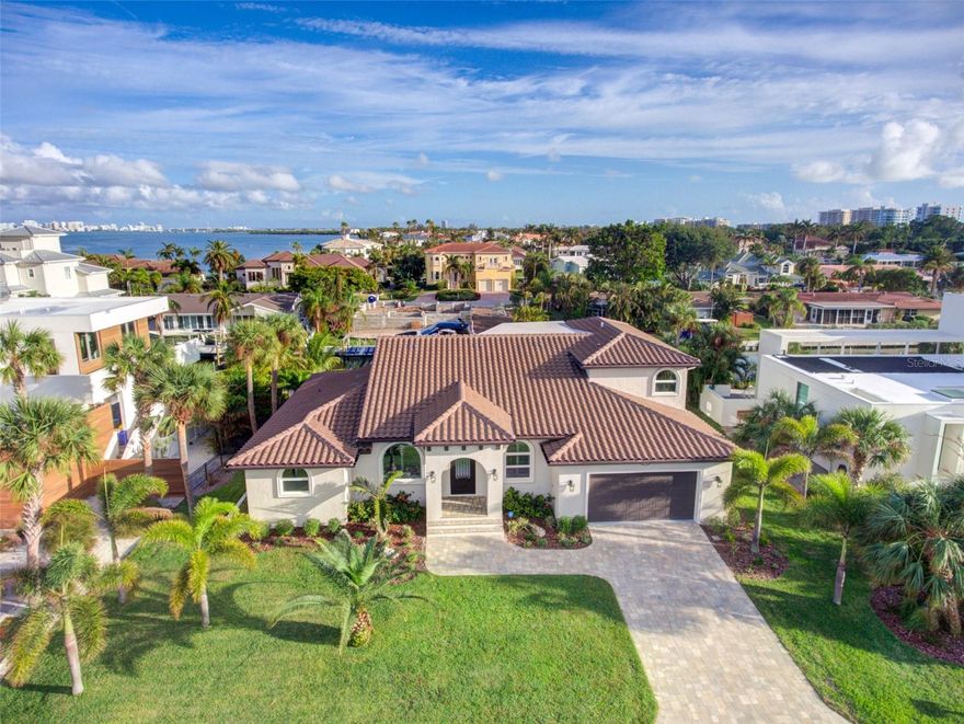 A rare opportunity to secure a single-family home with 100’ of canal frontage that has direct access to beautiful Sarasota Bay.— A RECENTLY RENOVATED home in beautiful Country Club Shores located on the more desirable southern end of Longboat Key. Home features 3,149 square feet of living space with 4-bedrooms and 3 full baths. Entering through an 8’ tall, arched iron front door you will discover a large great room with 16’ high ceilings and an open design concept . Completely replaced and renovated in 2018; tile roof, paver driveway, 2 Trane A/C units, tank-less water heater, sprinkler system, all railings, pool filter and pump. New stainless steel appliances, all interior doors and hardware, plantation shutters, LED lighting and porcelain tile floor throughout. The pool was refinished in deep blue Pebble Tec and is on the south (sunny) side of the property. The kitchen is spacious and open with solid wood, soft-close cabinets by Starmark and countertops in luxurious Cambria quartz. Boat lovers will appreciate the new seawall and the new 70’ private Trex dock with a 50 amp shore-power hookup and recently serviced 10,000 lb boat lift. — MOVE-IN READY with opportunity to personalize. The home offers an abundance of natural light and has a wide open floor plan with the current master bedroom on the upper level and three large bedrooms on the 1st level. The flexible layout offers the opportunity to create a 1st floor primary en-suite to suit your lifestyle. The existing large bedroom and bathroom with contemporary oversized his and hers sink vanity and large custom glass shower enclosure on the 1st floor can be customized to create a 1st floor master suite. — An exquisite solid oak, curved staircase leads to an upper-level deck with a water view. The owner’s suite features solid oak floors and his and hers walk-in closets. The master bath features handcrafted solid wood cabinets with quartz countertops, porcelain tile flooring, dual sinks, large enclosed shower and a whirlpool bath. —The first floor has three large guest bedrooms, one of which is set up as an office with custom built-ins. There are also two full baths which have similar features with the master bathroom; handcrafted solid wood cabinets with quartz countertops, porcelain tile flooring, and large enclosed showers. There is a large formal dining area adjacent to the curved oak staircase. — The covered lanai and outdoor living area has a spacious two-level travertine deck that is the perfect area for entertaining, sunbathing, and watching the dolphins that occasionally swim by. The FLEXIBLE living space makes this home perfect for extended family, visiting guests and working from home. You will enjoy an opulent waterfront lifestyle in this spacious home with direct canal access to Sarasota Bay. Enjoy the private deeded beach which has the most spectacular sugar-soft, white sand on the Gulf of Mexico. This property is close to everything. Longboat Key Club’s 27-holes of championship golf and shopping on St. Armands Circle. Sarasota, with it's rich cultural arts scene and many fine dining options are just a short drive away.