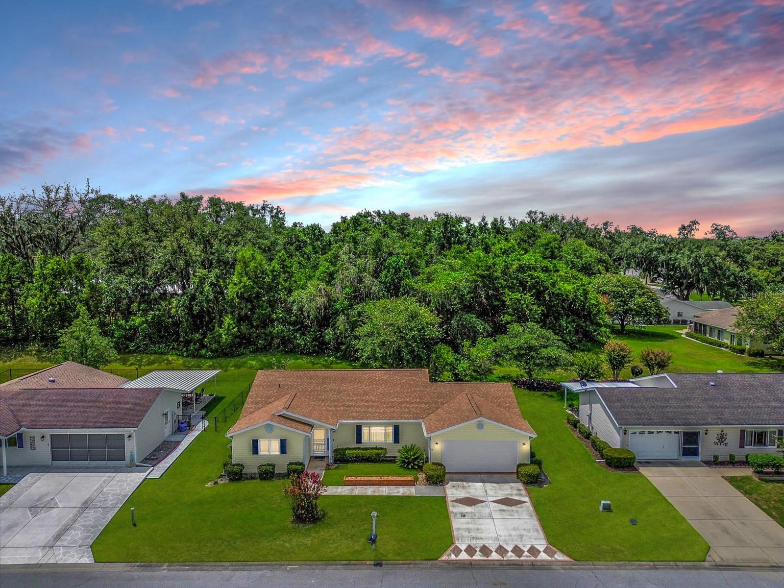 This spacious 2/2 Palm 3 Model offers 1,605 square feet under heat and air and sits on one of the most desirable homesites in Spruce Creek South — a deep backyard backing to WOODS for complete PRIVACY! You’ll love relaxing or entertaining in the 24' x 12' screened lanai, now tiled with the same beautiful 12” x 24” ceramic tile that runs throughout the home — NO carpet anywhere. Inside, the home has been professionally painted and thoughtfully updated. The remodeled kitchen features fresh painted cabinetry, stylish cabinet hardware, a skylight for natural light, and newer stainless steel appliances. A new roof (5/2025) and newer HVAC (9/2020) (Lennox 3-ton, 15.5 SEER) provide peace of mind, along with a newer hot water heater and a hot water recirculator pump (9/2020). Both bedrooms are oversized (16' x 14' & 14' x 12') — making it feel like you have two master suites. The garage (20.4' x 25.8') offers plenty of room for storage, hobbies, and even a golf cart. The huge interior laundry room (9.4' x 9.2') includes a top-of-the-line front-loading washer & dryer. Additional updates include replaced fans, fixtures, and lighting throughout, a screened front door, and a Ring doorbell. The fans in the living room, primary bedroom, and kitchenette area are remote controlled retractable fans with lights. This home is being sold fully furnished, so you can move right in and start enjoying the lifestyle! Best of all — the seller has an assumable mortgage at just 3.5% ($139,456.10 Remaining), offering incredible savings compared to today’s rates. Spruce Creek South is a desirable, gated 55+ golf community in Summerfield, just minutes from The Villages and surrounded by shopping, dining, and medical facilities. The community offers golf, a pool, fitness facilities, social activities, and more — everything you need to enjoy the Florida retirement lifestyle!