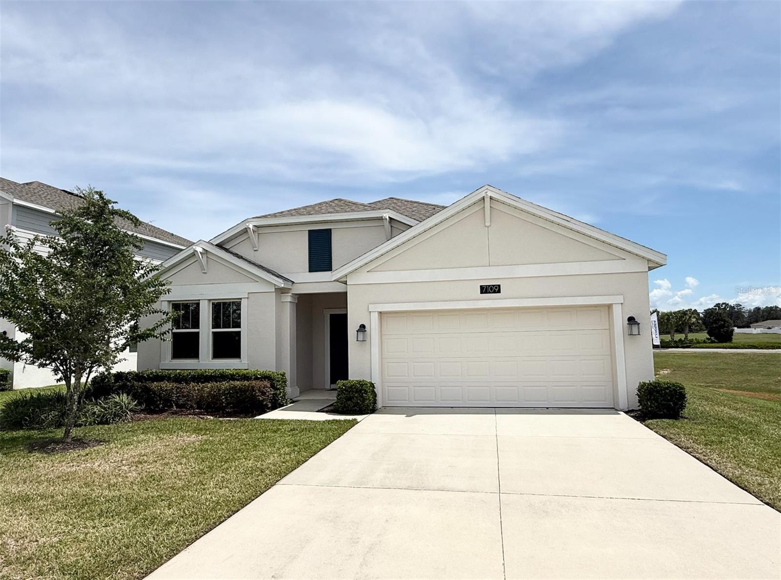 This never-lived-in former model home is in like-new condition and showcases a thoughtfully designed, family-friendly layout. A spacious foyer leads to three generously sized secondary bedrooms. At the heart of the home, the open-concept kitchen features 42" upper cabinets, quartz countertops, stainless steel appliances, and a central island—flowing seamlessly into a large family room and dining area, perfect for entertaining. A sliding glass door opens to a covered patio and expansive backyard—ready to be transformed into your own outdoor retreat. Privately tucked away in the rear of the home, the owner’s suite offers a peaceful escape with a luxurious bathroom that includes a dual-sink vanity, oversized shower, and spacious walk-in closet. To top it off, a full 4.875 KW solar system is included to help offset your utility bills and enhance energy efficiency. Located in the sought-after Trinity Lakes community, residents enjoy resort-style amenities including a sprawling zero-entry pool with splash pad, a state-of-the-art fitness center and clubhouse, a lakeside park with dock and covered wildlife viewing platform, a playground, scenic walking trails, and a dog park. Just minutes from the Florida Turnpike, Trinity Lakes offers convenient access to Central Florida’s premier attractions, including Walt Disney World Resort, Universal Orlando Resort, and SeaWorld. Enjoy world-class entertainment, shopping, dining, sports venues, and outdoor recreation—all within a 30-minute drive of downtown Orlando.