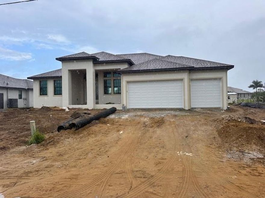 Under Construction. **Stunning Waterfront Home in South Gulf Cove** Welcome to your dream home! This beautiful property features 3 bedrooms, 3 bathrooms, and a den, perfectly designed for modern living. This home is currently under construction, and buyers may still make selections as long as materials have not been ordered. Please note: Photos shown are of similar completed homes, and certain finishes cannot be guaranteed. Situated on a seawalled lot with direct Gulf access, this home offers the best of waterfront living in the sought-after South Gulf Cove community. As you step inside, you'll be greeted by an open and airy floor plan with 14ft ceilings in the great room and 9ft ceilings throughout the rest of the home. The kitchen is a chef's delight, boasting high-quality dove-tailed, soft-closing cabinetry, and stunning granite countertops. Whether you're hosting a dinner party or enjoying a quiet evening at home, the spacious living areas provide the perfect setting. The primary suite is a true retreat, featuring a luxurious en-suite bathroom and ample closet space. Two additional bedrooms offer plenty of room for family or guests. The den can be used as a home office, library, or extra living space, adapting to your needs. Outside, the screened lanai and sparkling pool provide a private oasis for relaxation and entertainment.  With a decorative block wall at the water for Dramatic water view! The home is built with impact glass throughout, eliminating the need for hurricane shutters, and R-19 spray foam insulation in the attic ensures energy efficiency and comfort year-round. The 3-car garage offers plenty of space for vehicles and storage. Located in the desirable South Gulf Cove community, this home provides a perfect blend of luxury, convenience, and waterfront living. Buyers still have the opportunity to choose selections and colors, making this home uniquely theirs! Don't miss the opportunity to make this spectacular home yours. Schedule a showing today and experience the best of Florida living