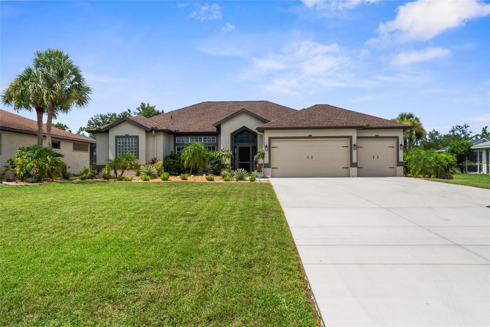 So many things to love about this house! As you approach the home, you'll notice that it sits well off the road, which allows for a long driveway with ample parking. You'll enter the front door and be greeted by an open, airy space with a wall of sliders which provide a peaceful view out to the lanai, pool, hot tub and large fenced yard. The primary bedroom and en suite bath are to the left, and have sliders out to the lanai. On the other side of the house, you'll find the other 2 bedrooms, one of which is enormous with TWO walk in closets. The other bedroom has one walk in closet and sliders to the lanai. The hall bathroom, which also has access to the lanai, was recently updated with a walk in shower, glass door and accent wall for a spa like experience. The 3 car garage is oversized with a bump out in the back which would be an idea space for a workbench, freezer or storage. The garage also offers epoxy flooring and TWO closets for extra storage. Landscaping and new curbing was completed within the last year. You'll be proud to call this one yours!