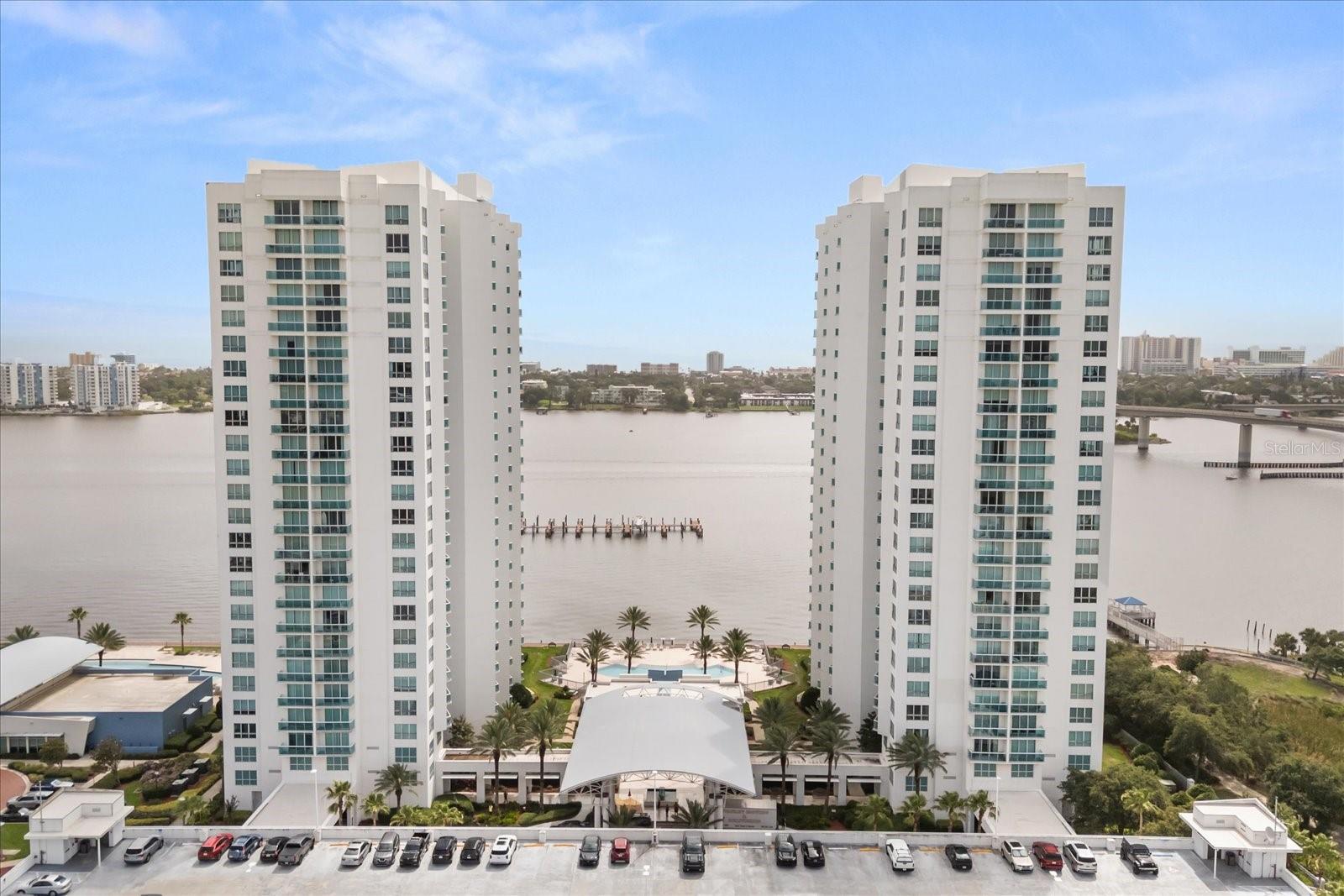 Welcome to 241 Riverside Drive, Unit 902 – a stunning 3-bedroom, 3-bath riverfront condo located on the 9th floor of the exclusive Marina Grande towers. This beautifully appointed residence offers over 2,000 square feet of open-concept living, wrapped in floor-to-ceiling windows that showcase sweeping views of the Intracoastal Waterway.
From the moment you enter through the welcoming foyer, you’re drawn into a light-filled living and dining space that flows seamlessly into a chef-inspired kitchen—perfect for entertaining or simply relaxing while taking in the water views. Step out onto the expansive private balcony and enjoy morning sunrises or peaceful evenings overlooking the river.
The spacious primary suite features a tranquil sitting area, a large walk-in closet, and a luxurious en-suite bath with dual vanities, a soaking tub, and separate shower. A second en-suite bedroom offers privacy and comfort for guests, while the third bedroom is conveniently located near the third full bathroom—ideal for a home office or additional guest room. An in-unit laundry room adds everyday convenience.
Marina Grande is a premier waterfront community offering world-class amenities on 18 acres, including two resort-style pools, a 10,000 sq. ft. clubhouse, movie theatre, game rooms, a billiards lounge, fitness center, steam rooms, yoga studio, and available boat slips. With a quarter-mile riverwalk, luxury living just minutes from the beach and all that Daytona has to offer, this is coastal living at its finest.
Don’t miss your opportunity to own this beautifully upgraded condo in one of Holly Hill’s most desirable addresses.