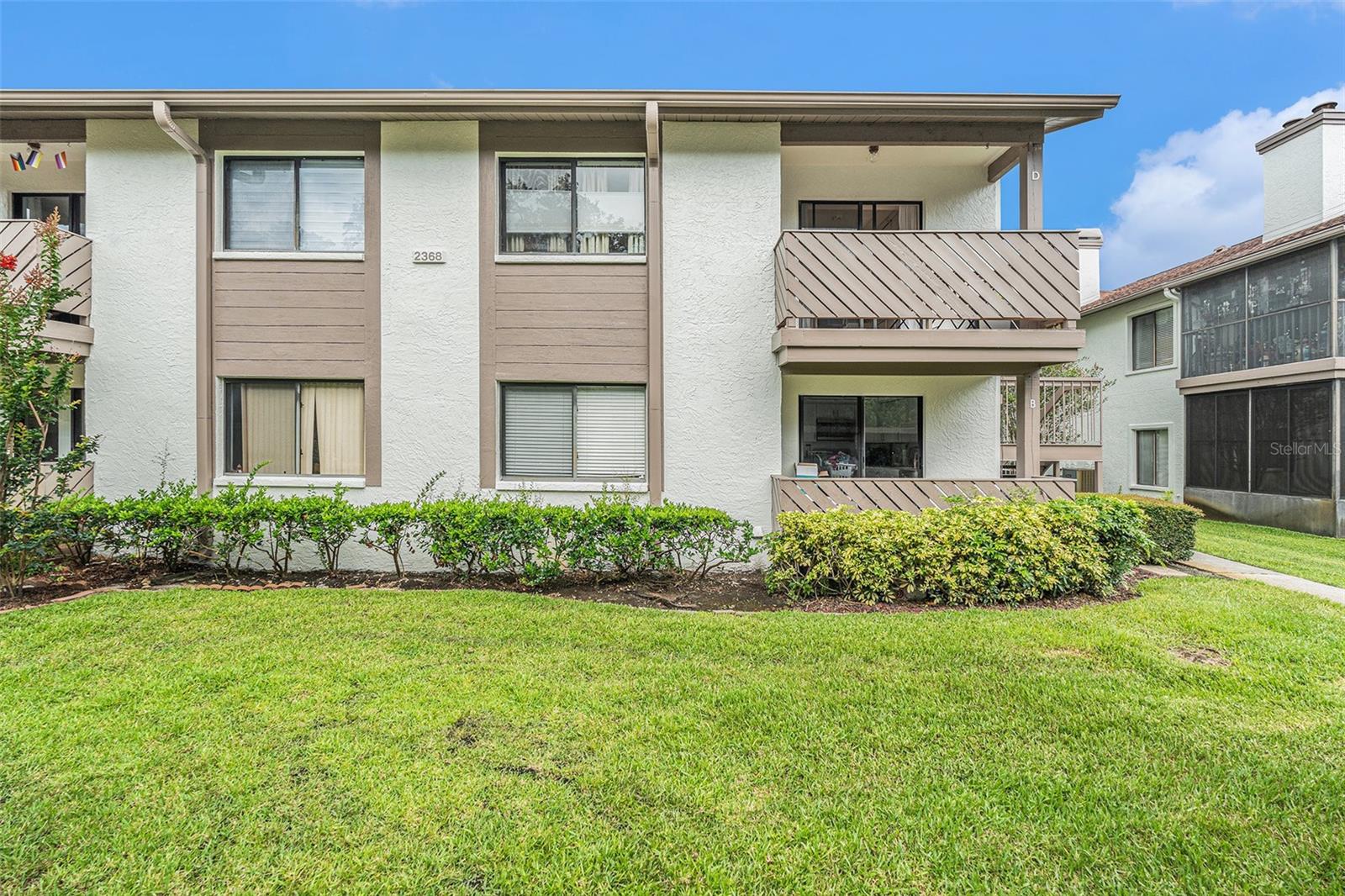 Beautiful two bedroom, two bath, 1,060-square-foot condo with warm and cozy ambiance in charming Safety Harbor. Fully furnished and move-in ready, this second-floor corner unit has large windows with ample natural light overlooking peaceful views of trees and green space. The interior walls and ceilings are recently painted, and gleaming wood floors with soundproofing are installed throughout. Floor plan provides a long and spacious living area, a roomy kitchen, a dining nook and split bedrooms. The primary bedroom in rear of condo has lots of space to spread out, a walk-in closet and a view of the trees outside. The attached master bathroom offers a step-in shower with natural stone tile. At the other end of the condo, the guest bedroom makes a perfect sleeping, office or private guest space. The adjacent bathroom in hallway includes a tub with shower, new vanity and new tile. Kitchen has generous space for food prep on a recently installed solid wood countertop with new drop-in sink. Window above the sink provides natural lighting with sill for plants and decor. Large sliding glass doors in kitchen lead to front balcony with new terracotta tile, a great space for growing plants or enjoying outside time in the cooler months. At the other end of the condo, another set of sliding doors leads to the large screened-in balcony, a perfect haven for enjoying morning coffee and relaxing. Balcony has new terracotta tile, four moveable privacy screens and a mini fridge. Other improvements by current owner include light-filtering cellular blinds and new ceiling fans in living room and bedrooms, new bathroom fans and bathroom shelving, a water softener system and a Watts under sink reverse osmosis water filtration system. Owners have access to the swimming pool, the clubhouse and overlook of a pond fringed by cypress trees. The condo is walking or cycling distance to beautiful Phillipe Park and downtown Safety Harbor, which offers shops, a library, dining, breweries, live music and events. Just down the street, Marshall Park offers nature trails, a playground, pickleball courts and other sports. Yorktown is a non-age restricted community, and units can be leased. Owners are allowed two small pets under 25 pounds. The HOA is proactive with upkeep, including weekly landscape maintenance, recent repainting of buildings and recent asphalt repaving.
